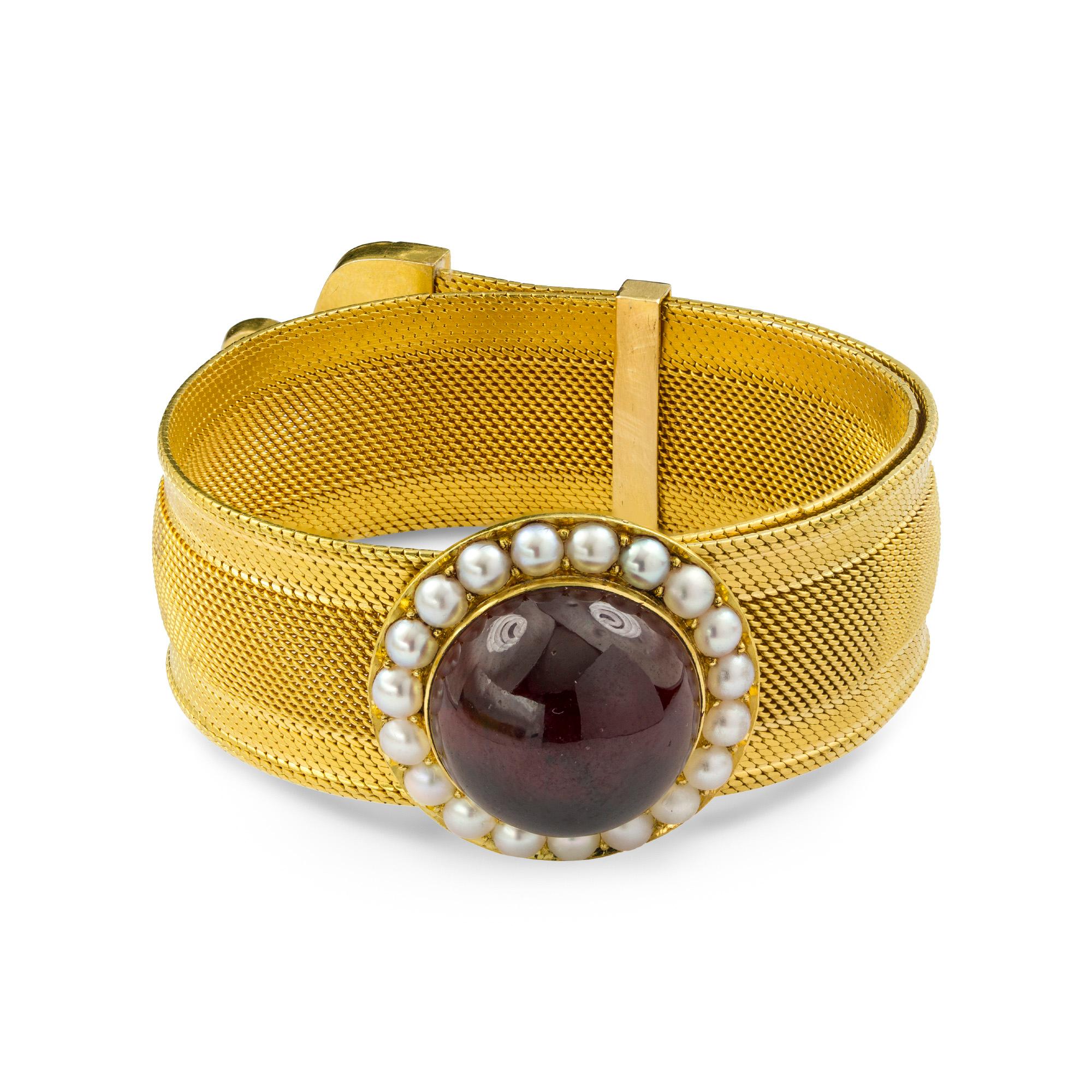 A Victorian garnet and half pearl bracelet, the central slide set with cabochon-cut garnet measuring approximately 17.2mm in diameter, surrounded by nineteen half pearls, on a gold mesh bracelet terminating with a line of half pearls and triangular
