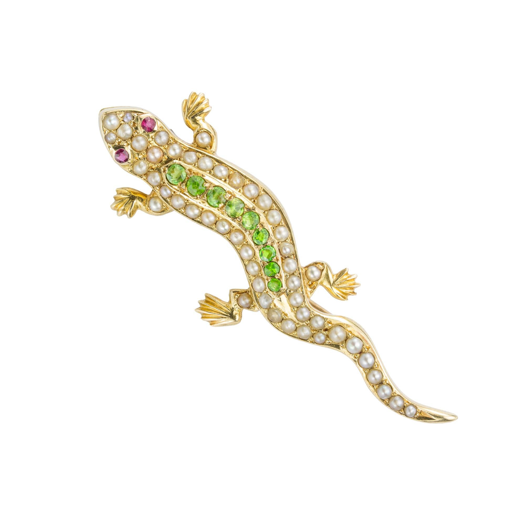 A Victorian demantoid garnet and pearl lizard brooch, the body set with a central row of graduating round faceted demantoid garnets and two half pearl-set rows on the side, with faceted ruby-set eyes and half pearl-set legs, all set in yellow gold,