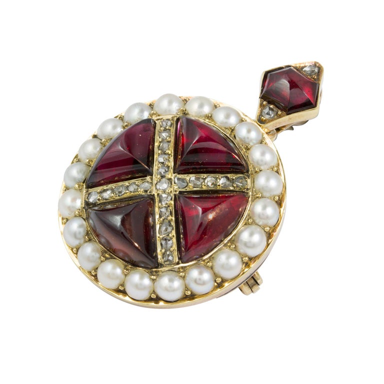 A Victorian garnet, pearl and diamond brooch/pendant, set to the centre with four triangular cabochon-cut garnets between rose-cut diamond-set cross and natural pearl surround, with cabochon-cut garnet and rose-cut diamond loop, all set in a yellow