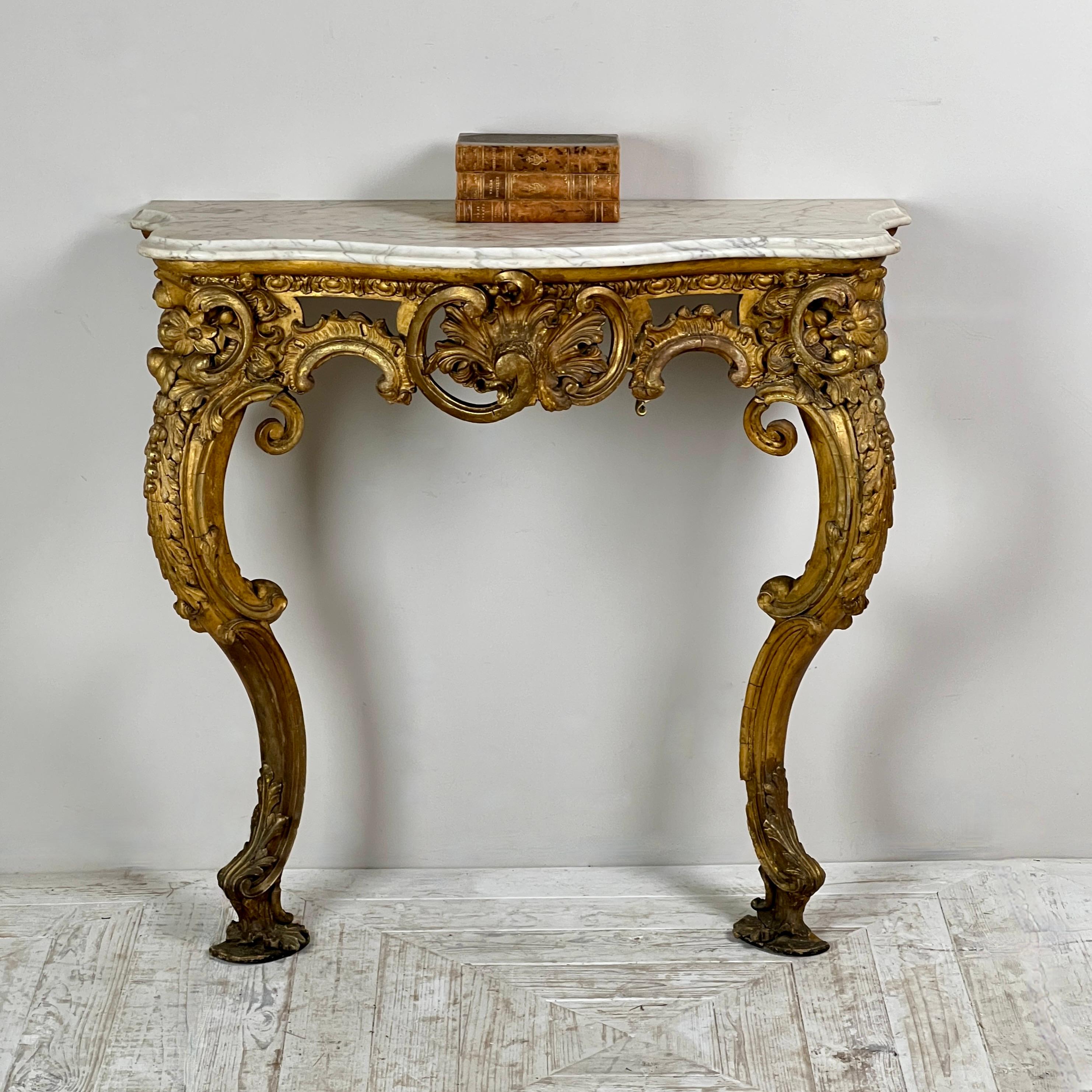 This smart Victorian console table features a beautifully crafted Carrara marble top of serpentine shape, accentuated by an attractive ogee lip. The giltwood and gesso base is a true testament to the era's craftsmanship, showcasing an intricately
