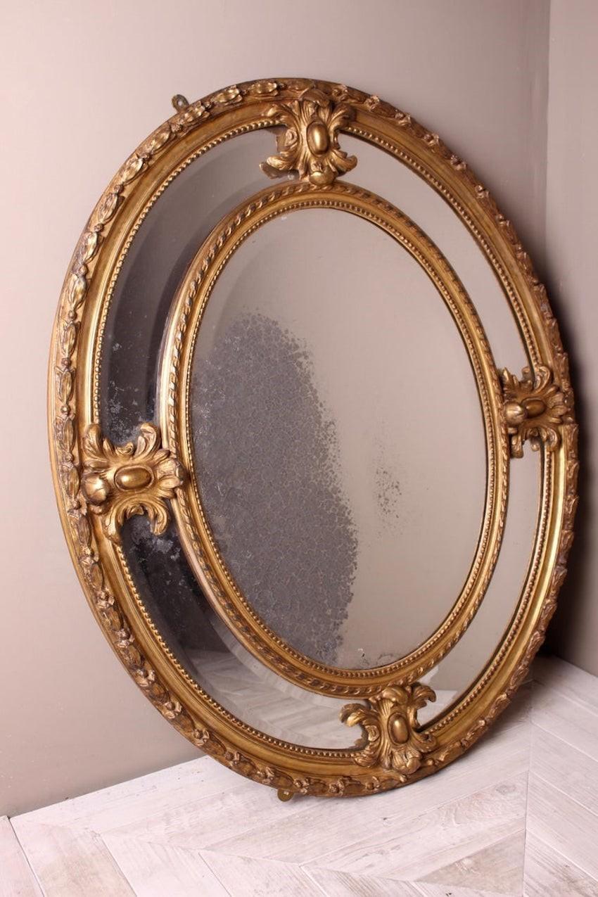Un beau miroir victorien en bois doré, de bonnes proportions. Le cadre ovale en bois et gesso est également orné de cartouches attrayants. Le bord extérieur est orné d'un feuillage appliqué. Les plats extérieurs et intérieurs ont un bord biseauté,