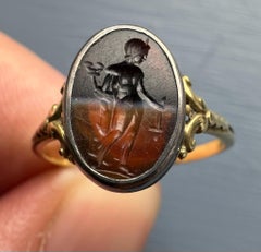 A Victorian gold and silver ring set with a Roman banded agate intaglio. Mercury
