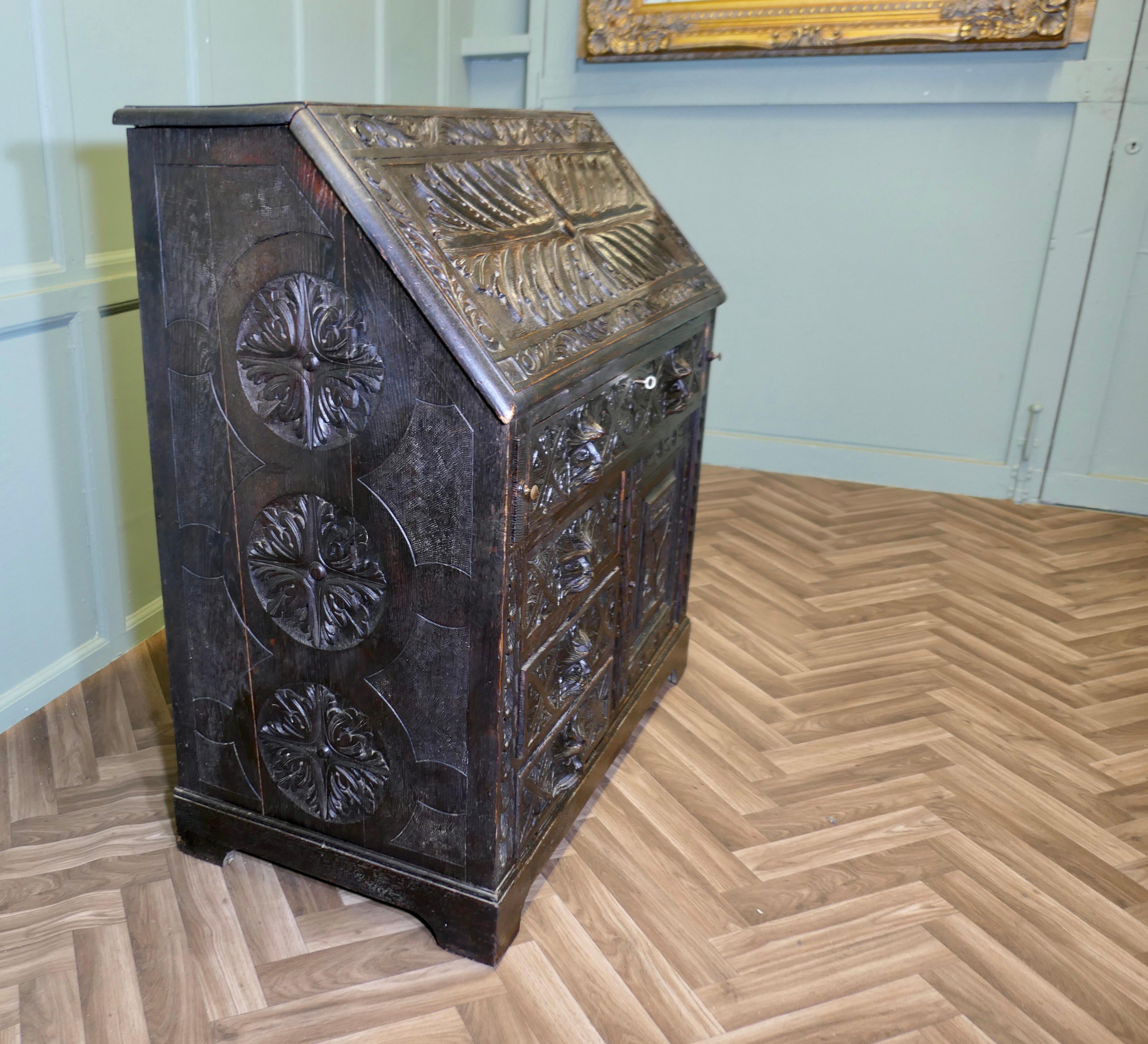 A Victorian Green Man Carved Oak Bureau 

The bureau is superbly carved with acanthus leaves and faces of the green man from solid oak, it has a carved fall front, one long drawer and 3 shorter drawers these all have carved fronts and with the face