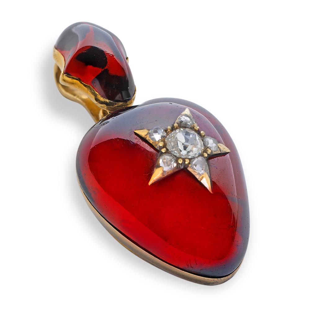 A Victorian heart-shaped garnet and diamond pendant, the cabochon-cut garnet with a diamond-set star motif applied to the centre, the old brilliant-cut diamond estimated 0.30 carats all to a yellow gold mount with glass locket at the back and