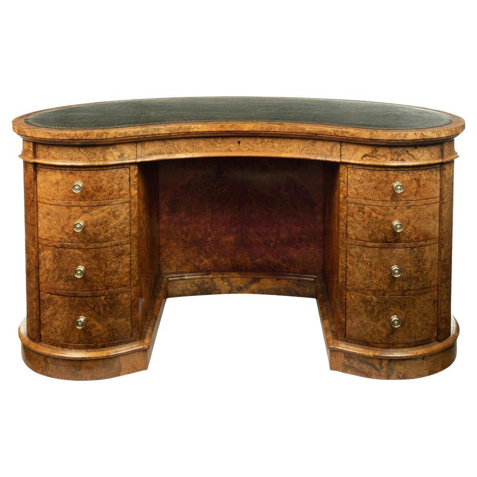 A Victorian kidney shaped desk in richly figured burr walnut, attributed to Gill