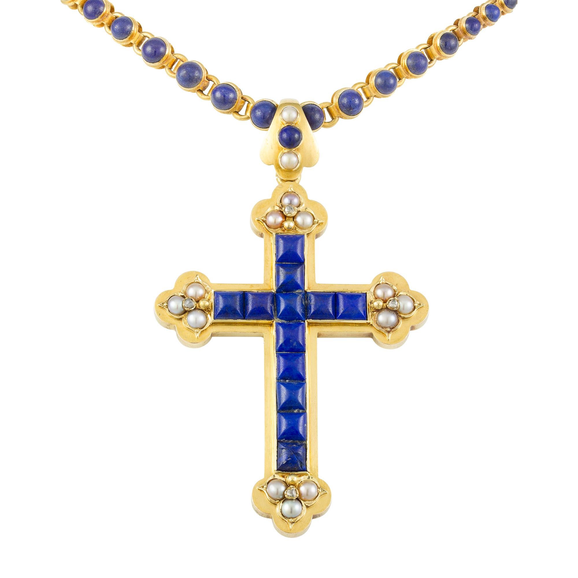 A Victorian lapis, half pearl and diamond pendant, in the form of a stylised Latin cross, set with twelve square cabochon-cut lapis and embellished with four fleur-de-lis clusters of half pearls and old-cut diamonds, to closed satin-finish yellow