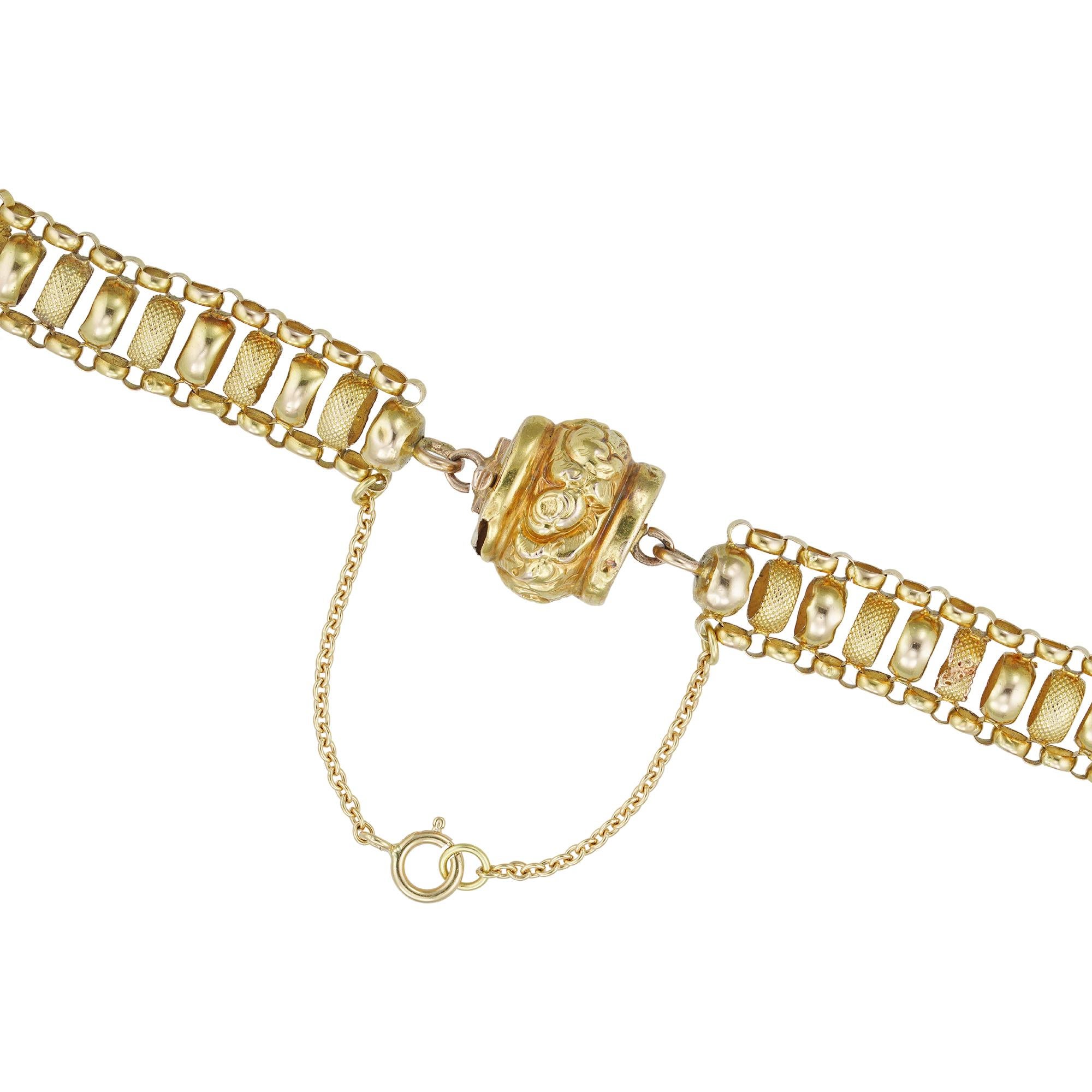 A Victorian long yellow gold chain, the chain comprising alternately-set plain and textured cylindrical yellow gold loops, with smaller cylindrical links lining either side, to a ball snap clasp with floral decoration, measuring approximately 138 x