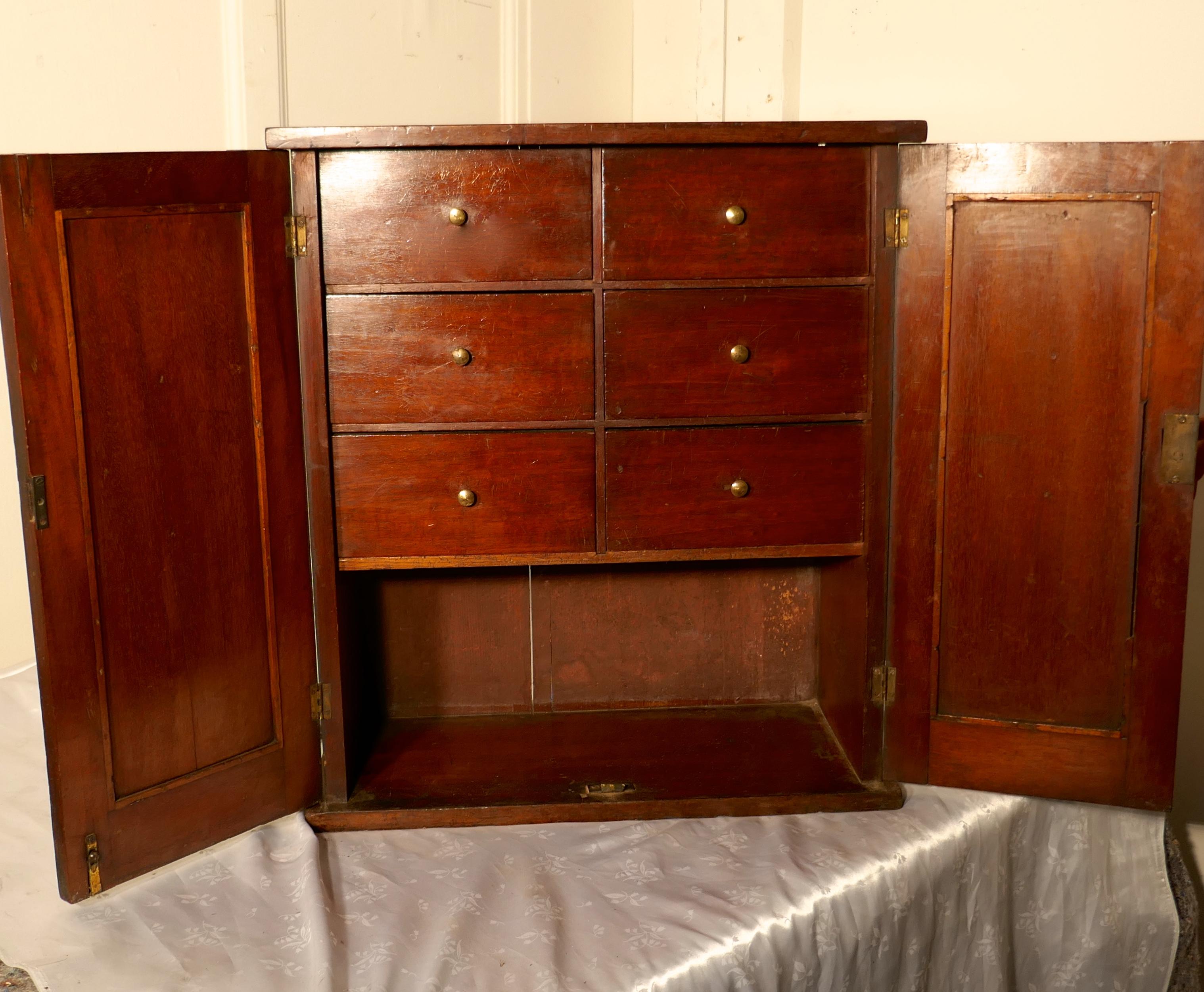 A Victorian mahogany collectors cabinet, with interior drawers

The cabinet has 2 panelled doors behind which there are 6 drawers 
The cabinet is made in solid mahogany it is in good sound condition with key and working lock
The cabinet is 20.5”