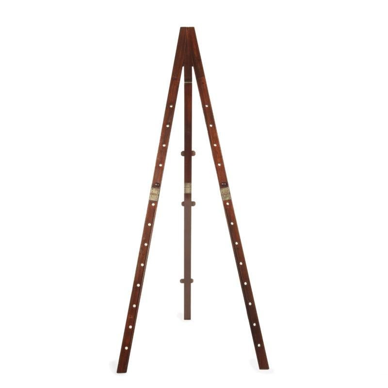 A Victorian mahogany tripod folding campaign easel, all three legs with lockable brass hinges, the two outer legs with 13 peg holes, the central one with a tapered end and two additional hinges, two pegs, standing more than 6 feet tall when open and