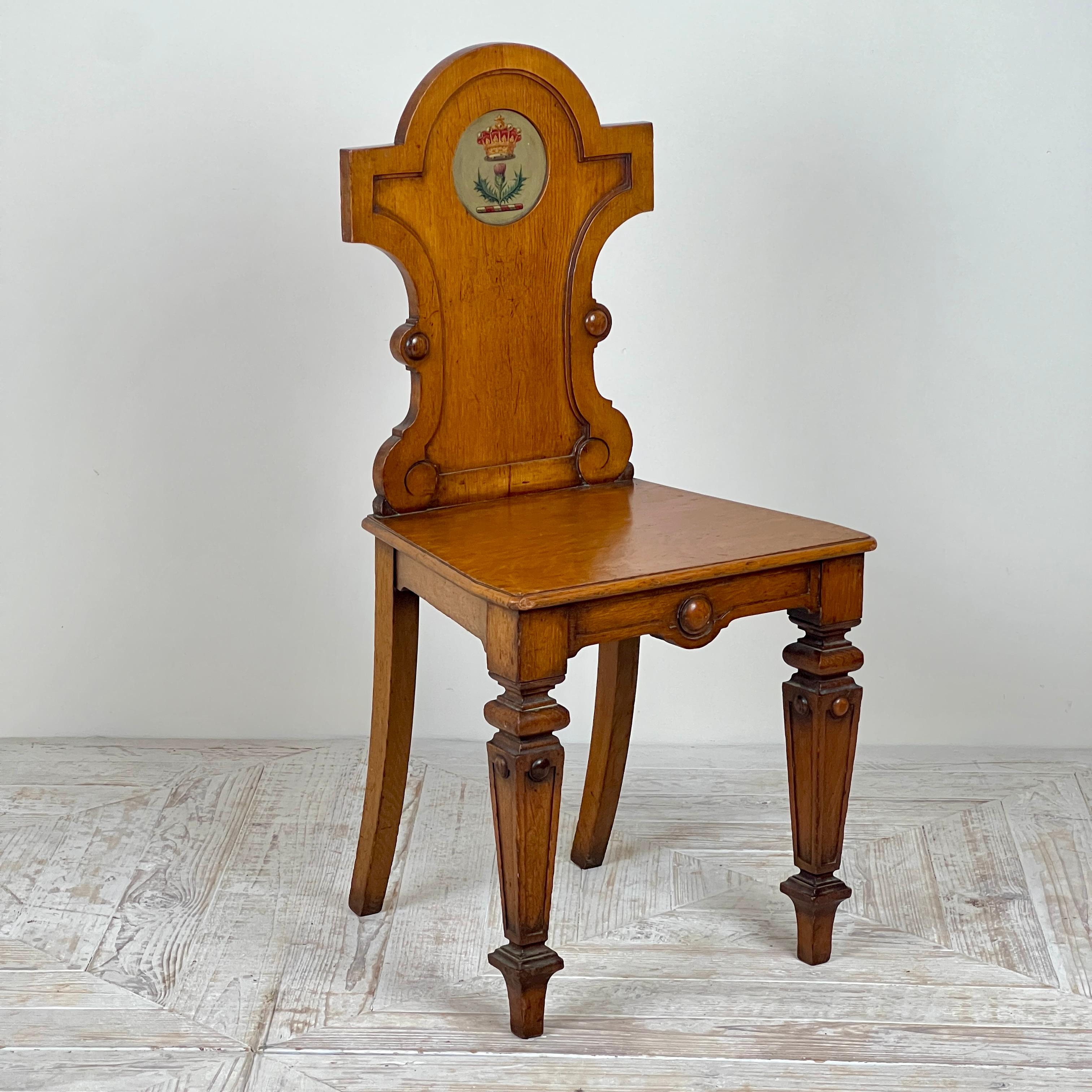 Una bella sedia da sala vittoriana in Oak con stemma del conte Coronet.

Questa sedia da sala in rovere chiaro presenta un elegante schienale a cucchiaio incassato, ornato da uno stemma circolare dipinto con una coronetta di Oak. Il sedile concavo