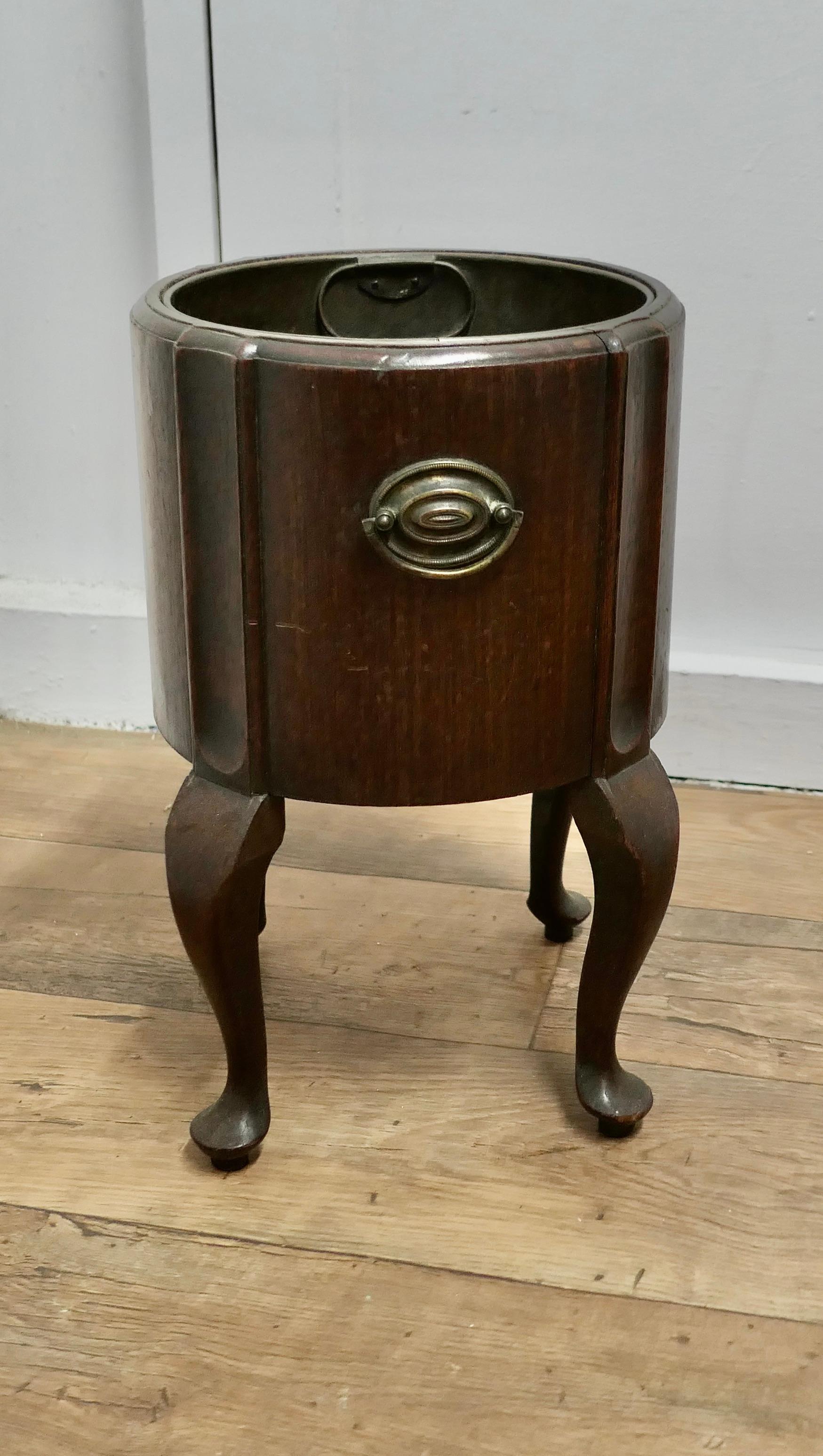 A Victorian Oak Wine Cooler, Planter Display 

This is a handsome piece, with Ring Handles, it stands on 4 cabriole legs and it has a removable brass liner
The wine cooler is 18” high, 12” wide overall and the liner is 9” in diameter and 9.5”