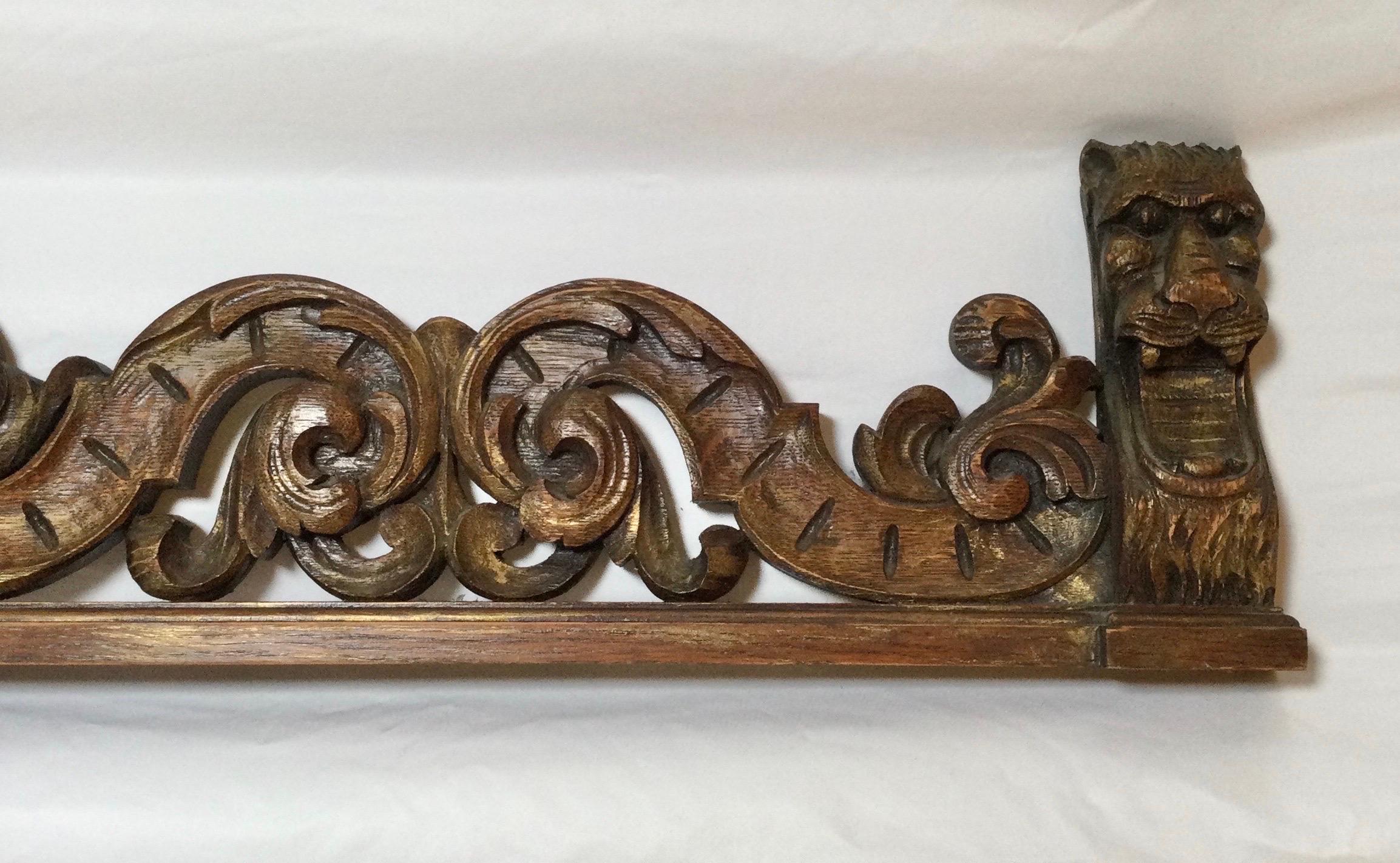 An ornately hand carved dark oak valance with lion head decoration on each end. The center with a mask of the lord of the winds carving flanked by beautifully caved scrolling. 71 inches wide, can be used over a door or archway or a window.