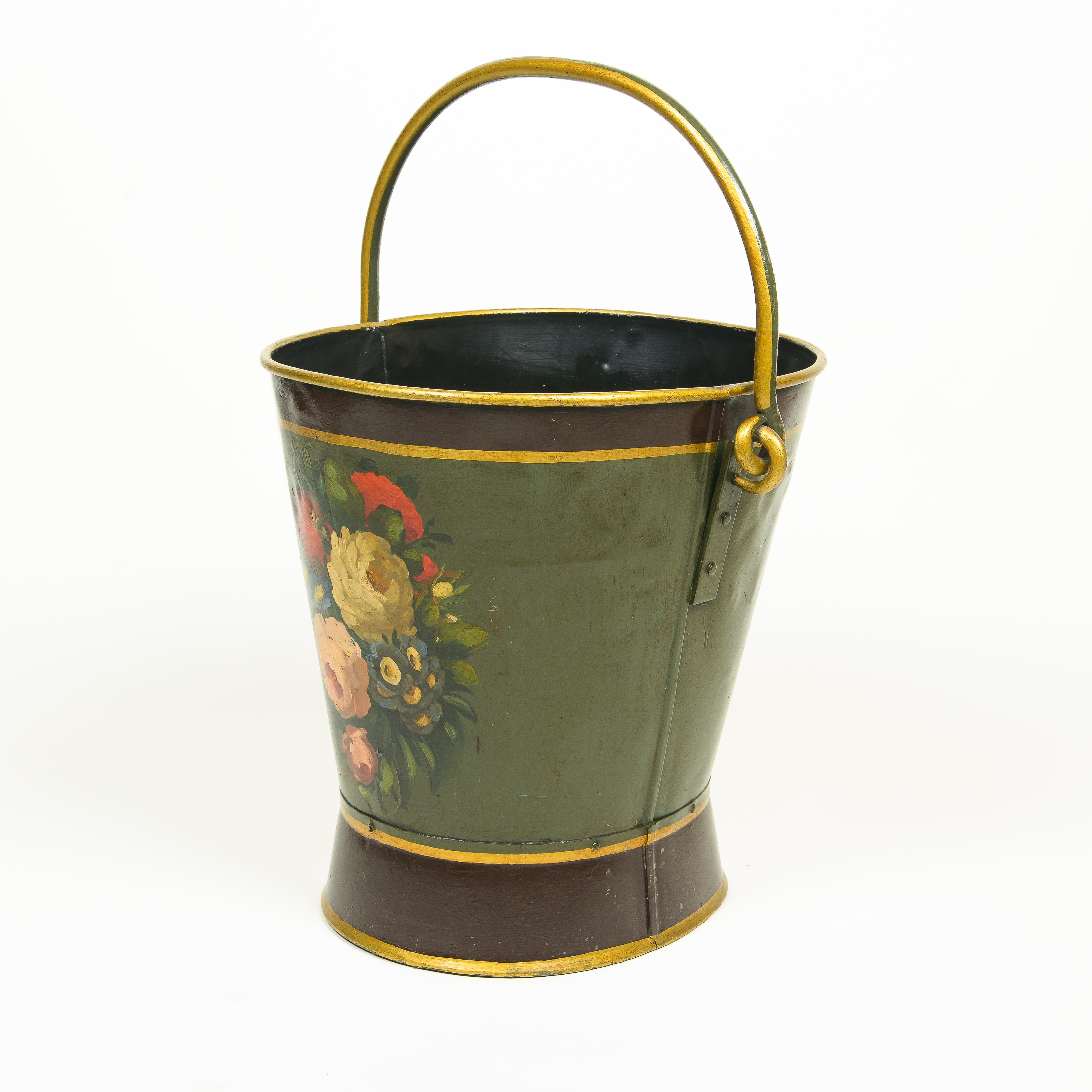 Of round tapering form with flared base; painted with roses and other various flowers on a moss green ground with gilt banding; mounted with carrying handle.