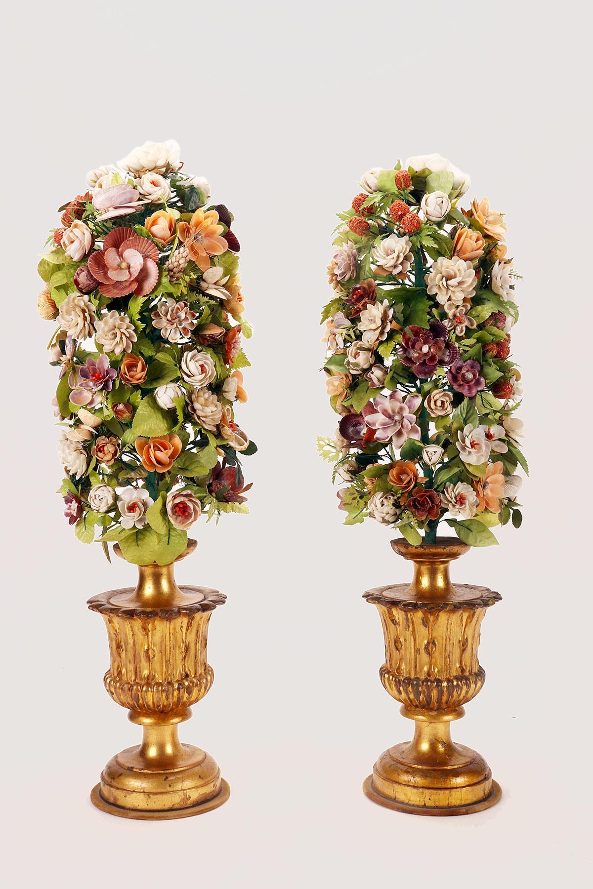 Ein viktorianisches Paar Blumenarrangements aus Muscheln und Korallen auf geschnitztem und vergoldetem Holzsockel. Jede der beiden Kompositionen hat einen Sockel aus geschnitztem und vergoldetem Obstholz, der die Vasenform mit einem komplexen Profil