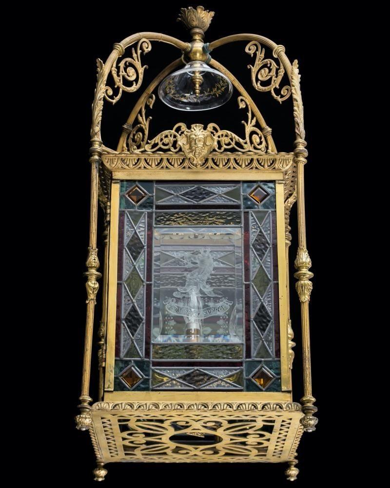 A fine aesthetic Victorian lantern with gilt bronze gallery incasing leaded stain glass panels each with engraved panels of flowers, birds and one with Cutler family crest inscribed 'Dum spiro spero'.


Measures: Height 91.5 cm (36