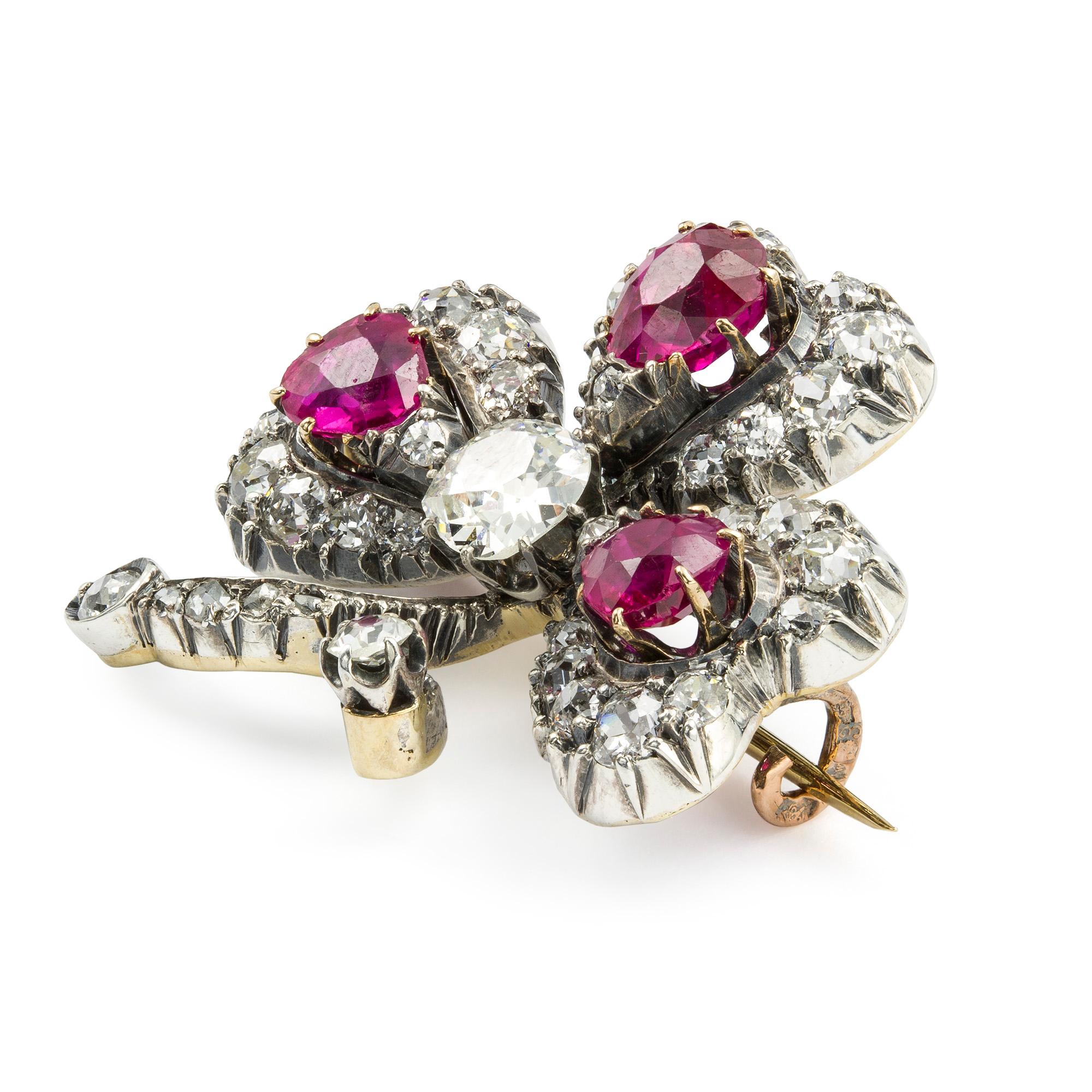 An early 20th century ruby and diamond three leaf clover brooch, the three faceted pear shaped rubies, estimated to weigh a total of 2.5 carats, with a cushion shape old brilliant-cut diamond centre, estimated to weigh 0.6 carats, each to a cluster