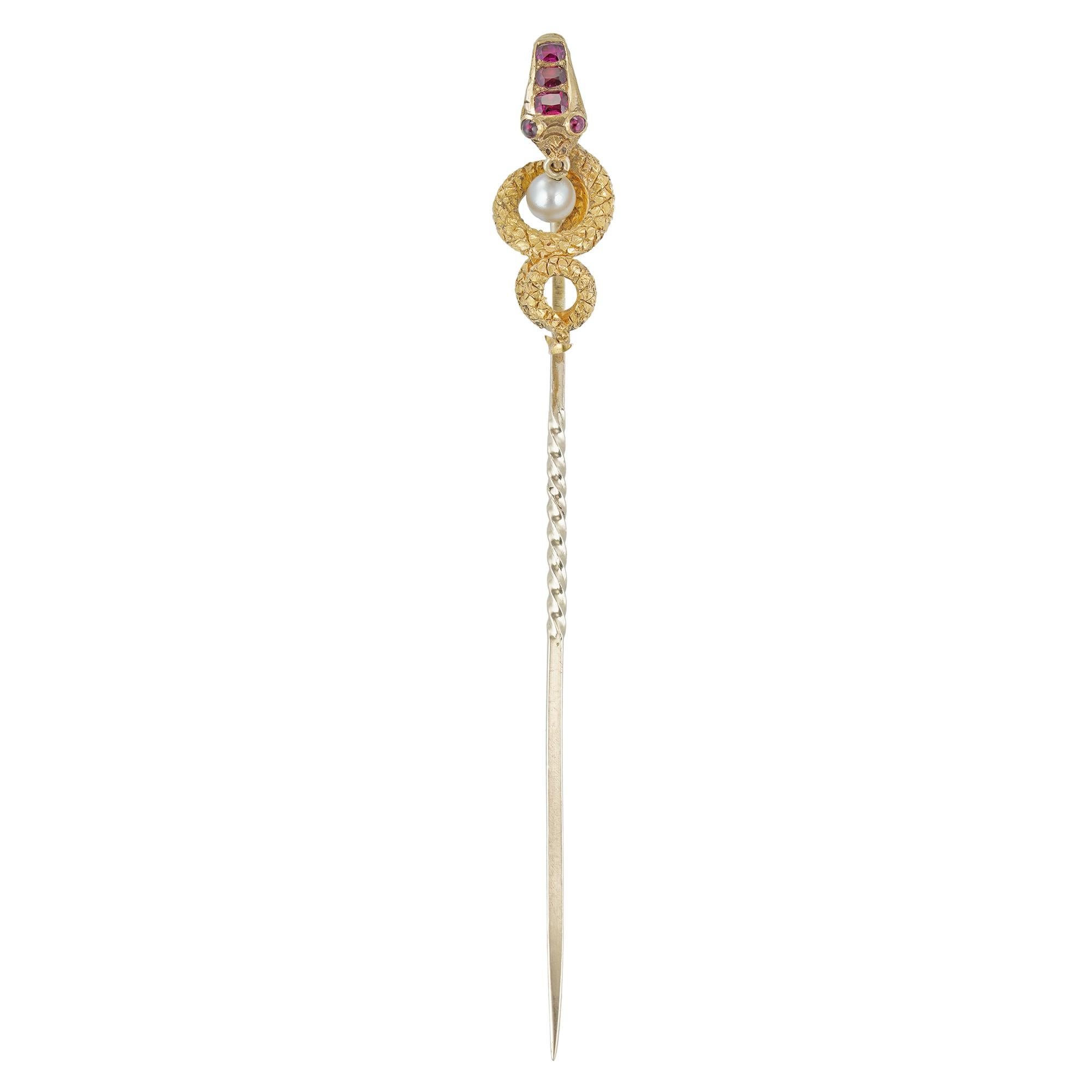 A Victorian ruby and pearl snake stick-pin, the coiled snake with three faceted rubies set on the forehead, two cabochon-set ruby eyes, suspending a pearl from the mouth, the finely engraved body mounted in yellow gold, circa 1880, the jewelled part