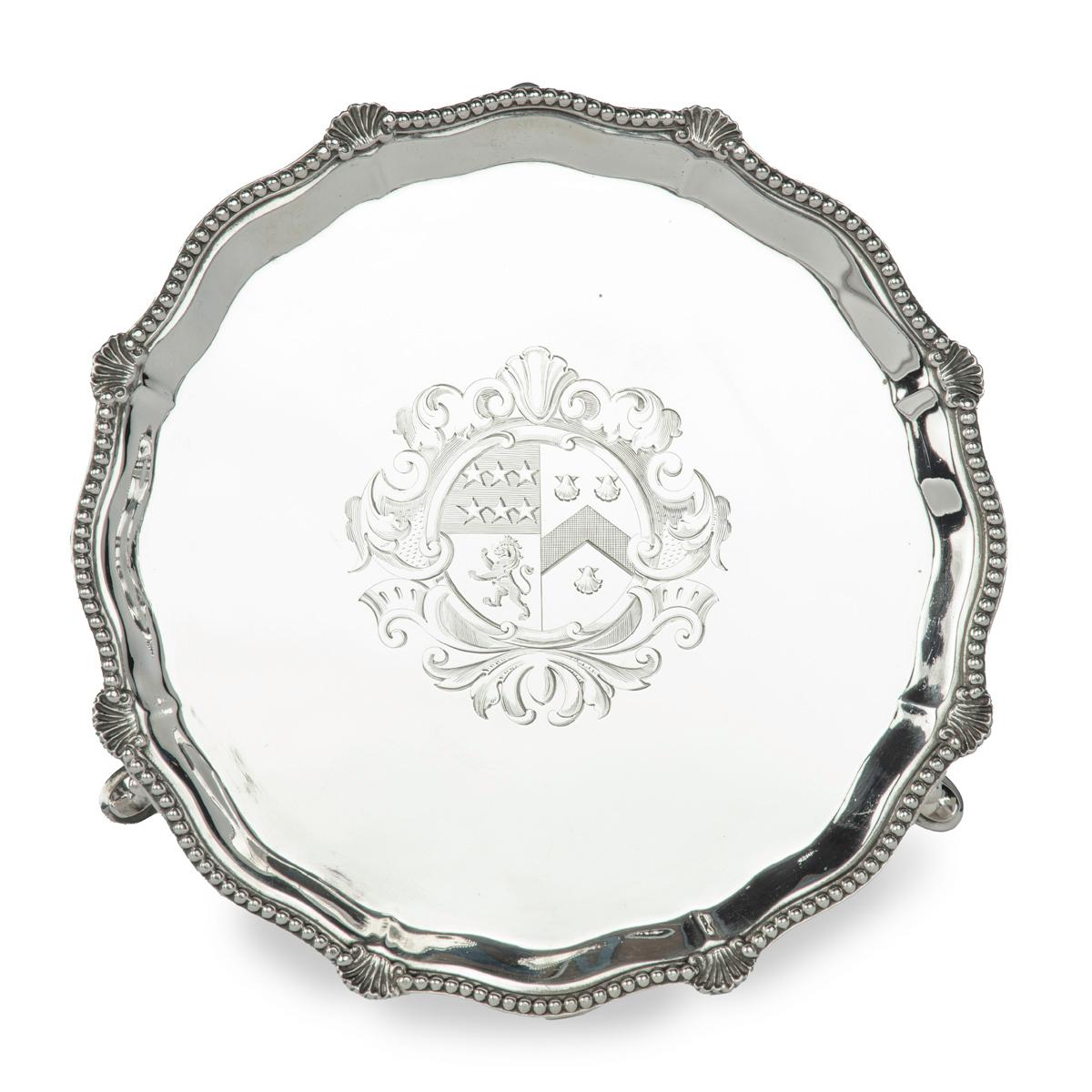 Bandeja de plata victoriana con el escudo de armas de Brig. General Sir Bertram Portal, 17º Lanceros,  De forma redondeada, con borde corcheteado y gorgoneado con ocho conchas de vieira, elevado sobre tres pies, inciso con un escudo de armas central