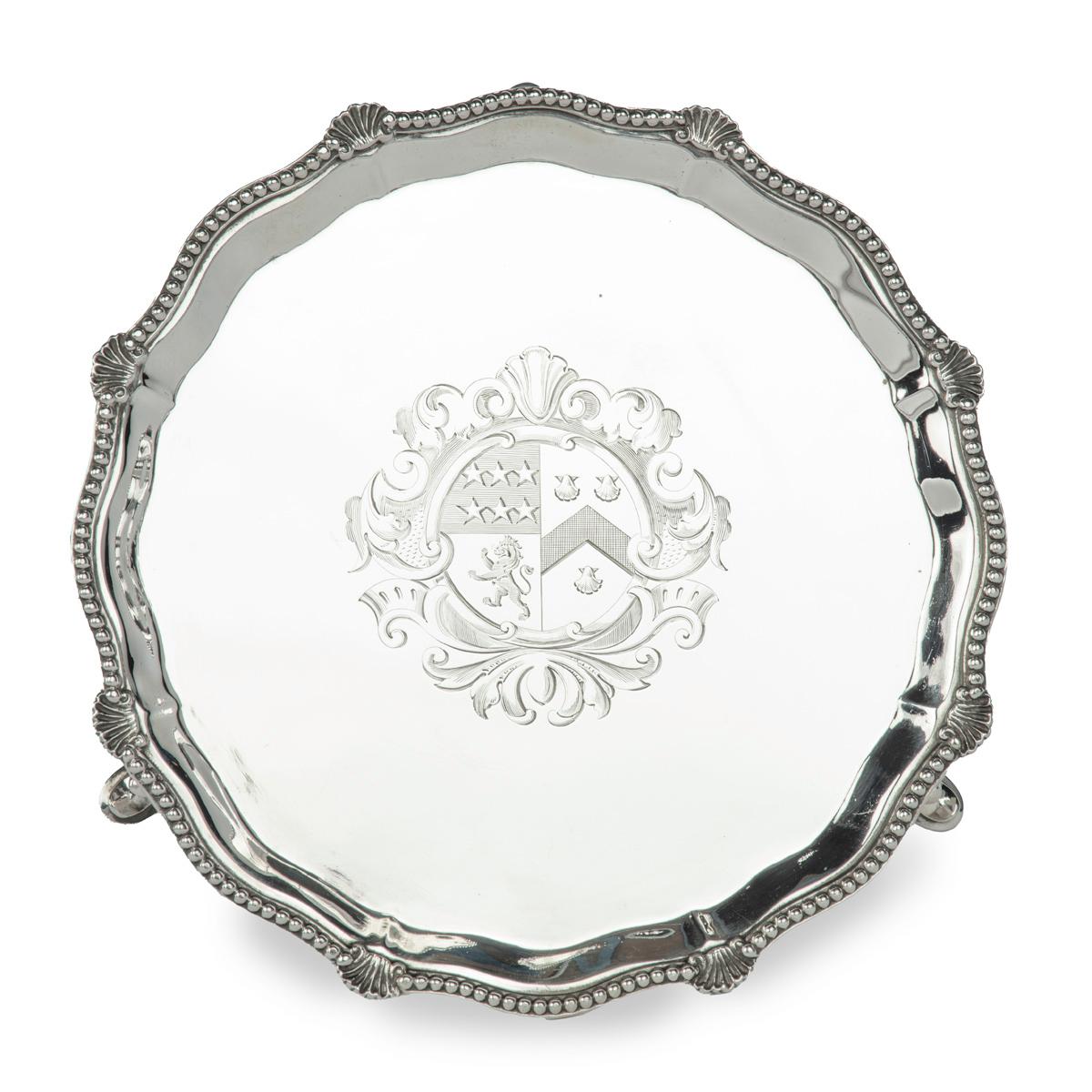 A Victorian silver armorial tray presented to Brig. General Sir Bertram Portal, 17th Lancers,  of rounded form with a bracketed, gadrooned rim with eight scallop shells, raised on three feet, incised with a central armorial on the front and on the