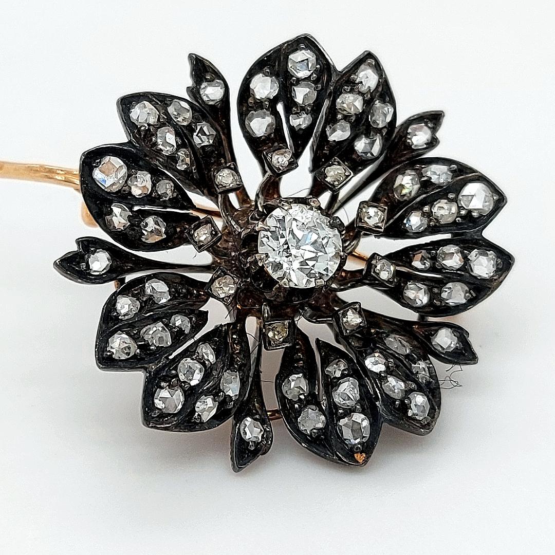A Victorian Silver on Gold Diamond Flower Brooch from Circa 1860, 

The pin of the brooch is 18kt gold, there is an option of taking the pin off and at the back of the jewel there are two hinges to be worn as a pendant when wanted.

Hallmarks :