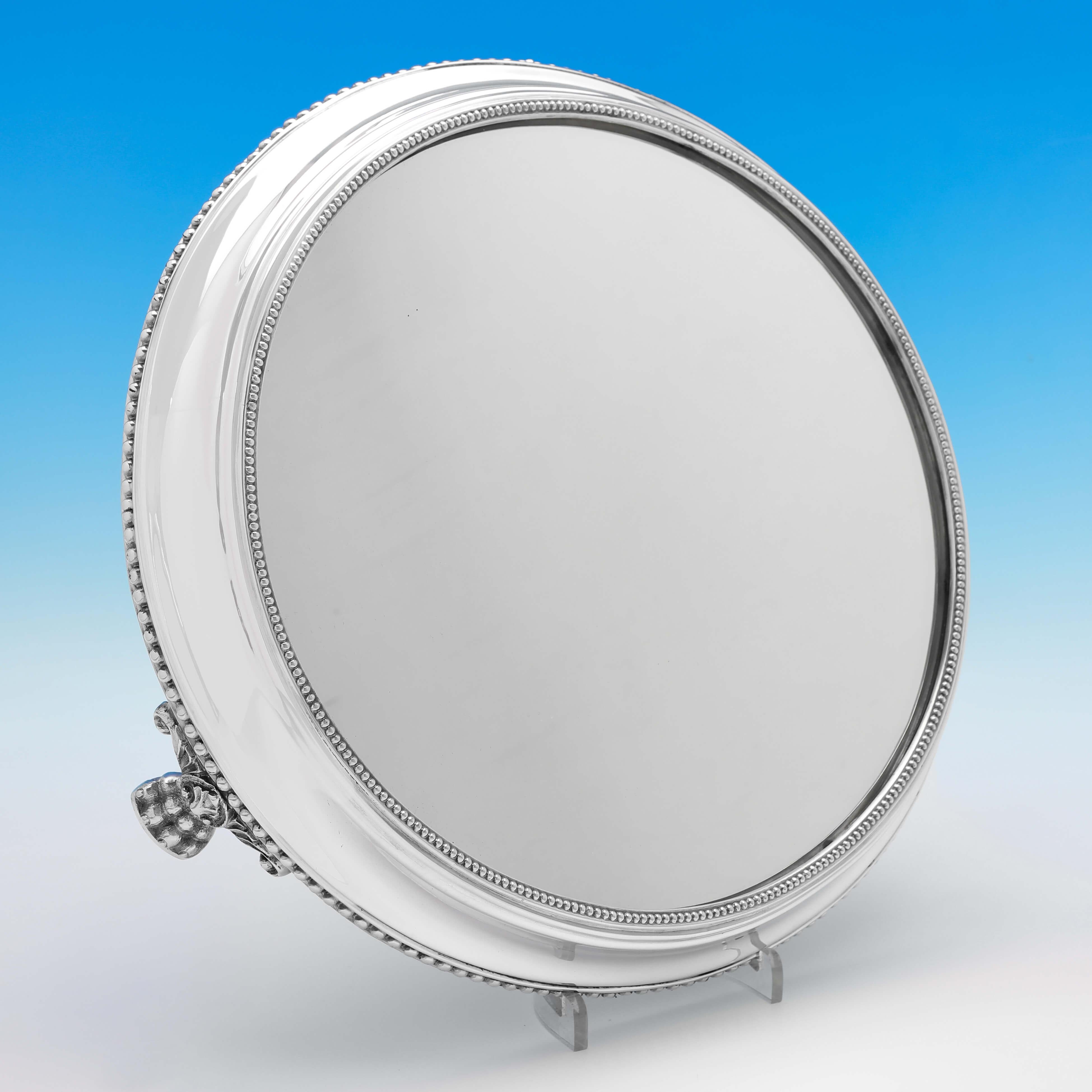 Hallmarked in Sheffield in 1885 by W. W. Harrison, this handsome, Victorian, Antique Sterling Silver Mirror Plateau, stands on 3 feet, and features bead borders to the base and top. 

The mirror plateau measures 3