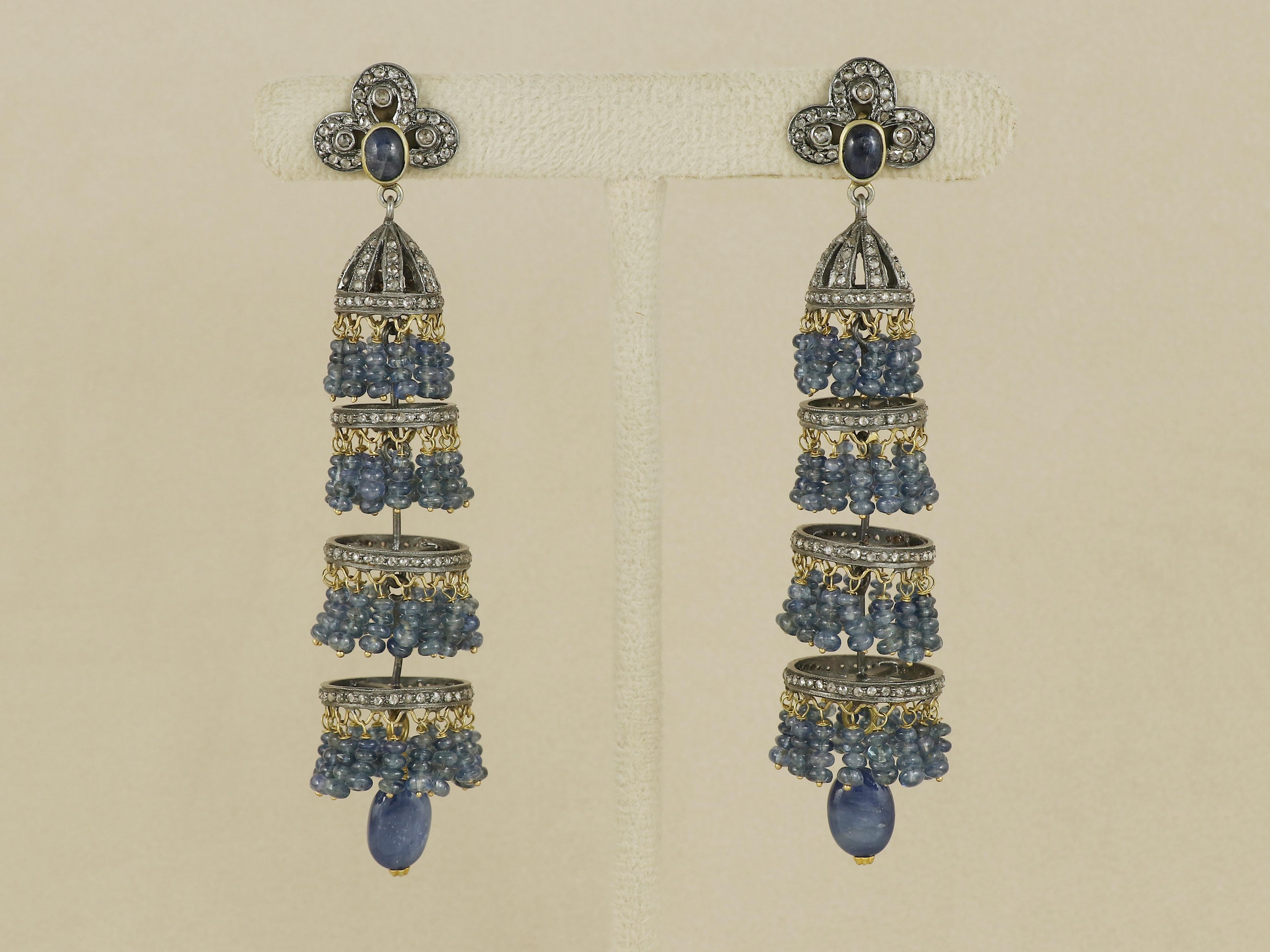 Découvrez l'élégance royale de l'ère victorienne avec ces magnifiques boucles d'oreilles pendantes, entièrement réalisées en argent et en or 18 carats. Le design est basé sur un saphir bleu naturel serti directement sur l'oreille, ce qui confère à