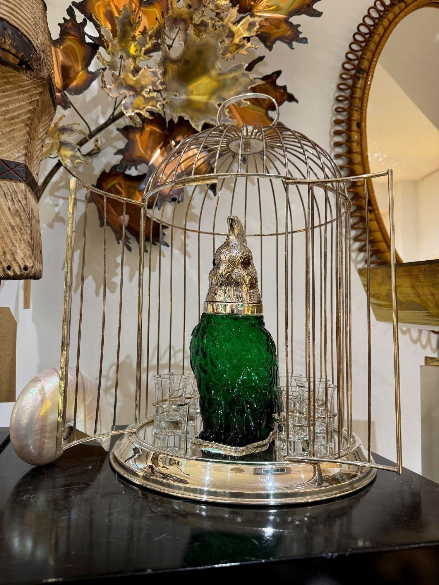 A wonderful English Victorian style green glass cockatoo decanter with silver plated head with hinged neck that opens. With ESPNS hallmarks on the neck. Mounted in a silver plated cage, with door doors and top handle. The decanter is mounted with 8