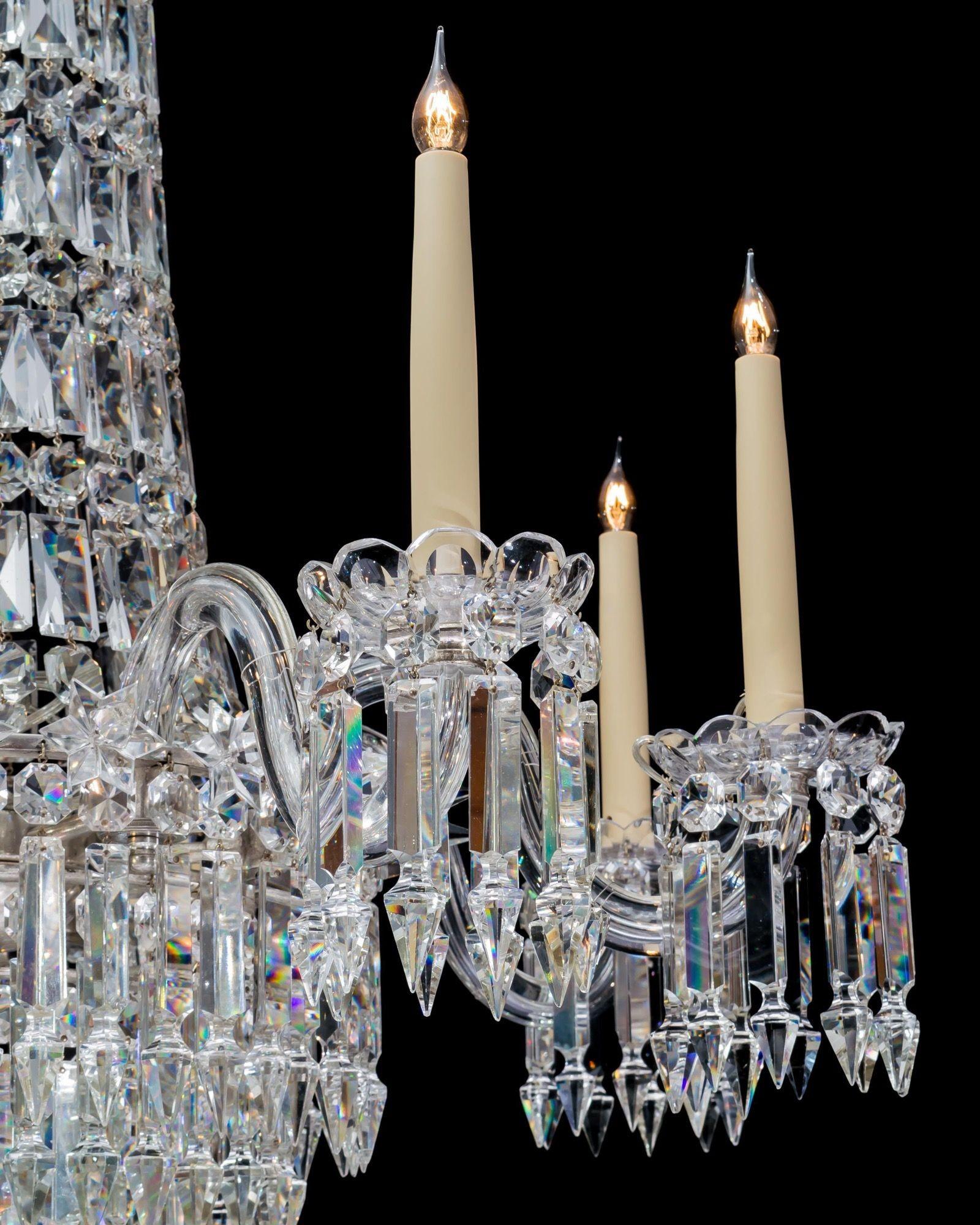 Lampadario a otto luci in vetro tagliato e argentato, di qualità precoce, dal classico design a tenda e a cascata, con stelo a forma di tromba e baldacchino a goccia con catene a cascata di tenda a fibbia e spighe. Il lampadario ha otto bracci a