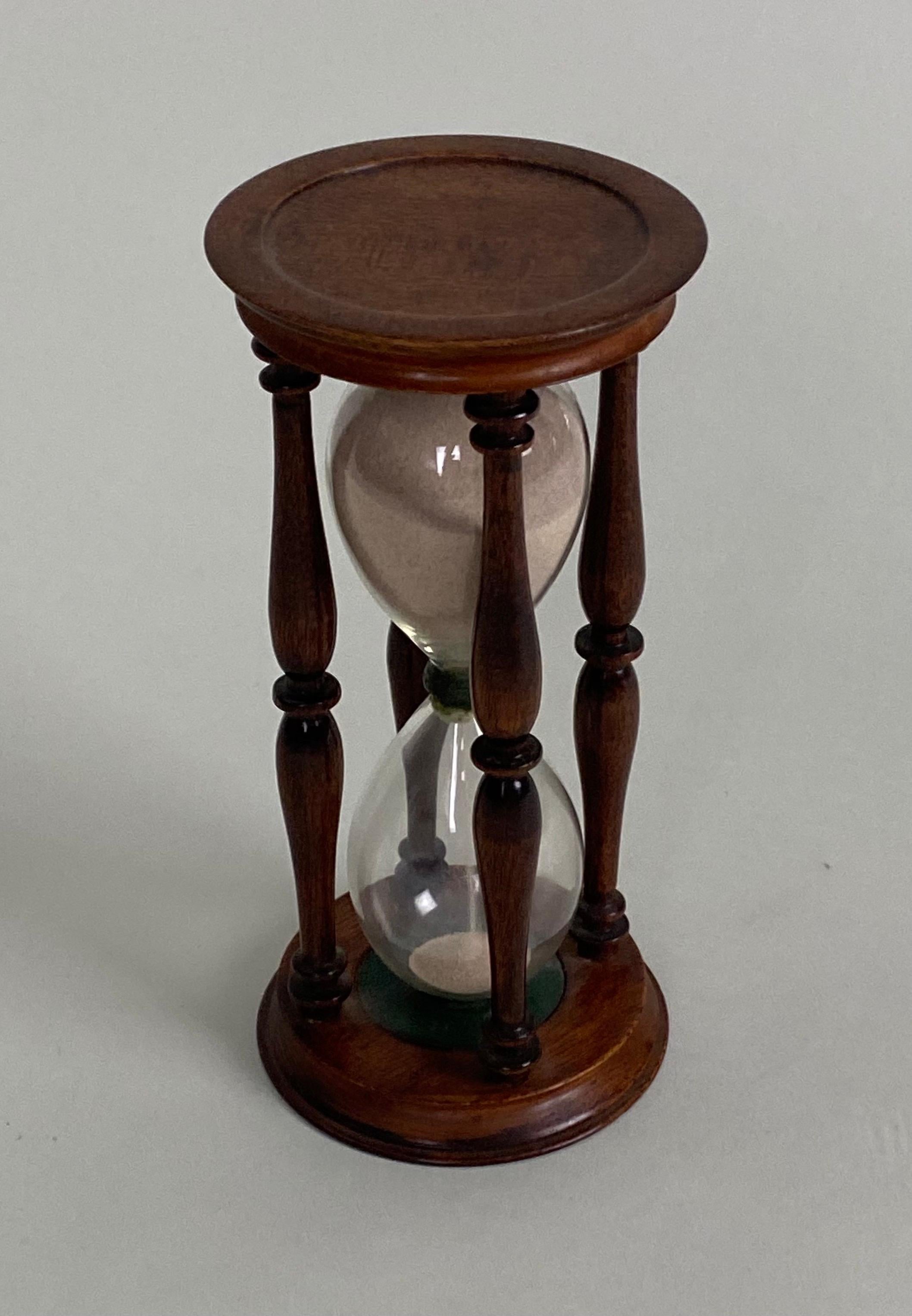 Victorian Hourglass within 4 turned wood balusters and top and bottom caps.