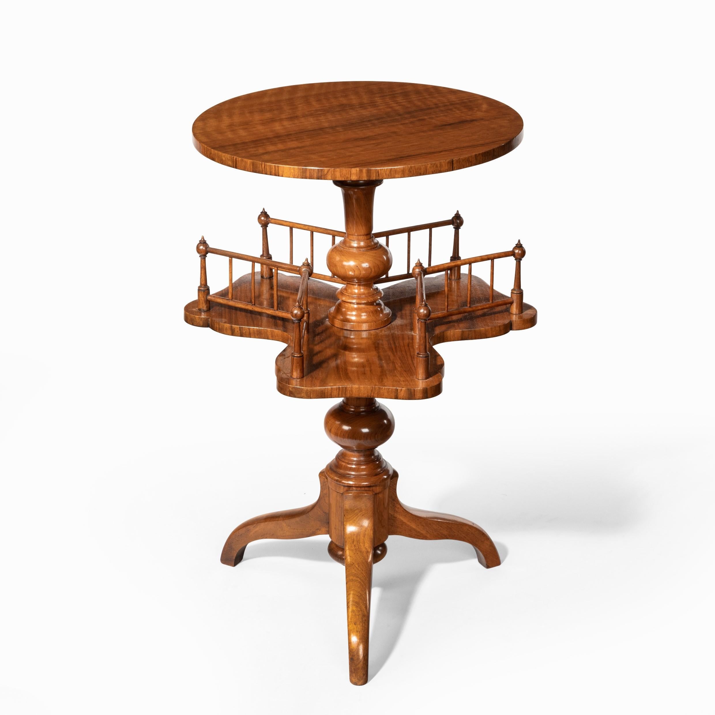 A Victorian walnut revolving book table, of typical form with a circular top above three shaped open book-shelves which revolve around a central turned support, all raised on three down-swept legs. English, 1880.