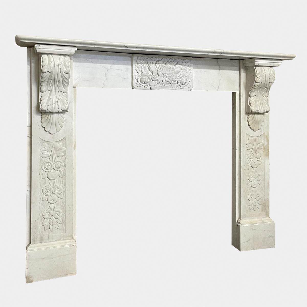 A Victorian antique marble fireplace carved in Statuary white marble. A reclaimed piece, restored as lovingly as possible. The jambs with panels of carved foliate, surmounted by carved acanthus leaf corbels. The frieze with centre tablet basket