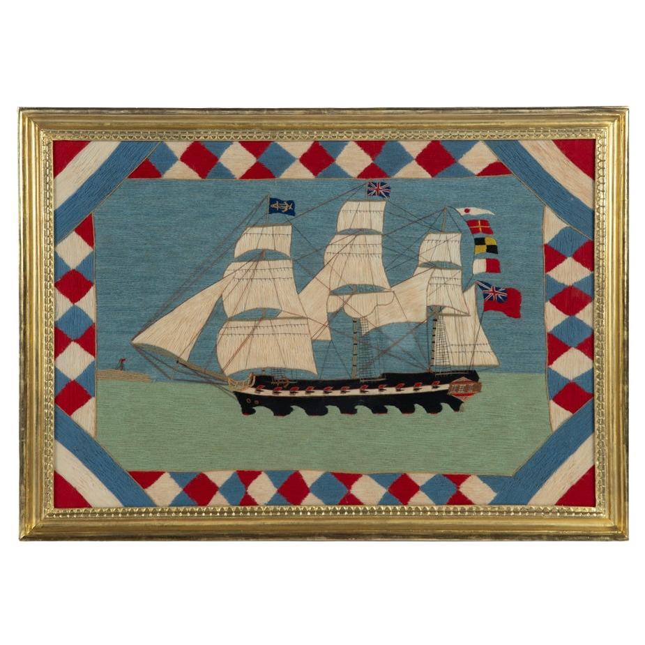 A Victorian wool picture of a three masted frigate flying several flags and ensi For Sale