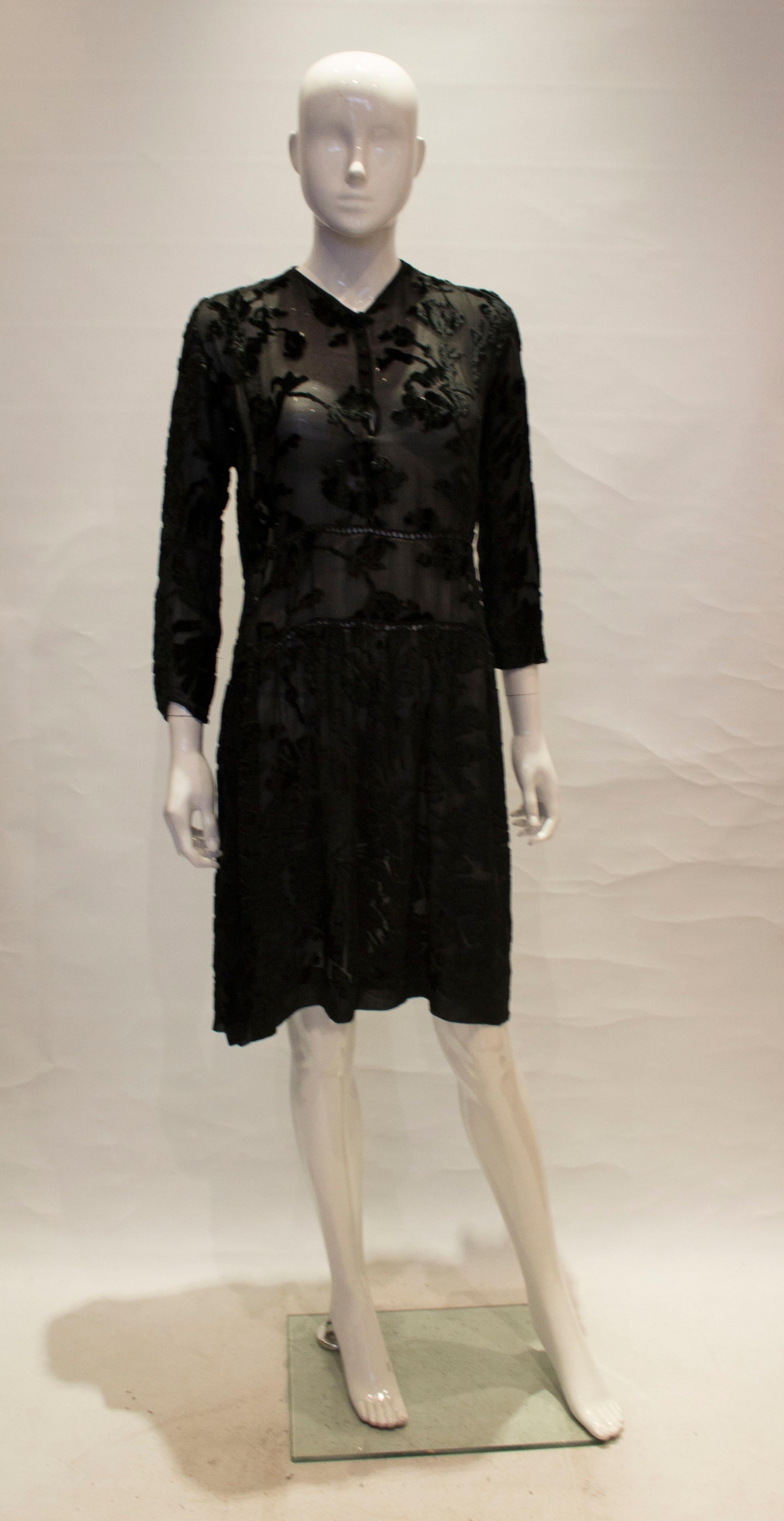 A lovely 1920s - 1930s black devore dress in a floral design, popper up the front,

measurements taken flat in inches 

bust - 18
waist - 17 
length - 40 