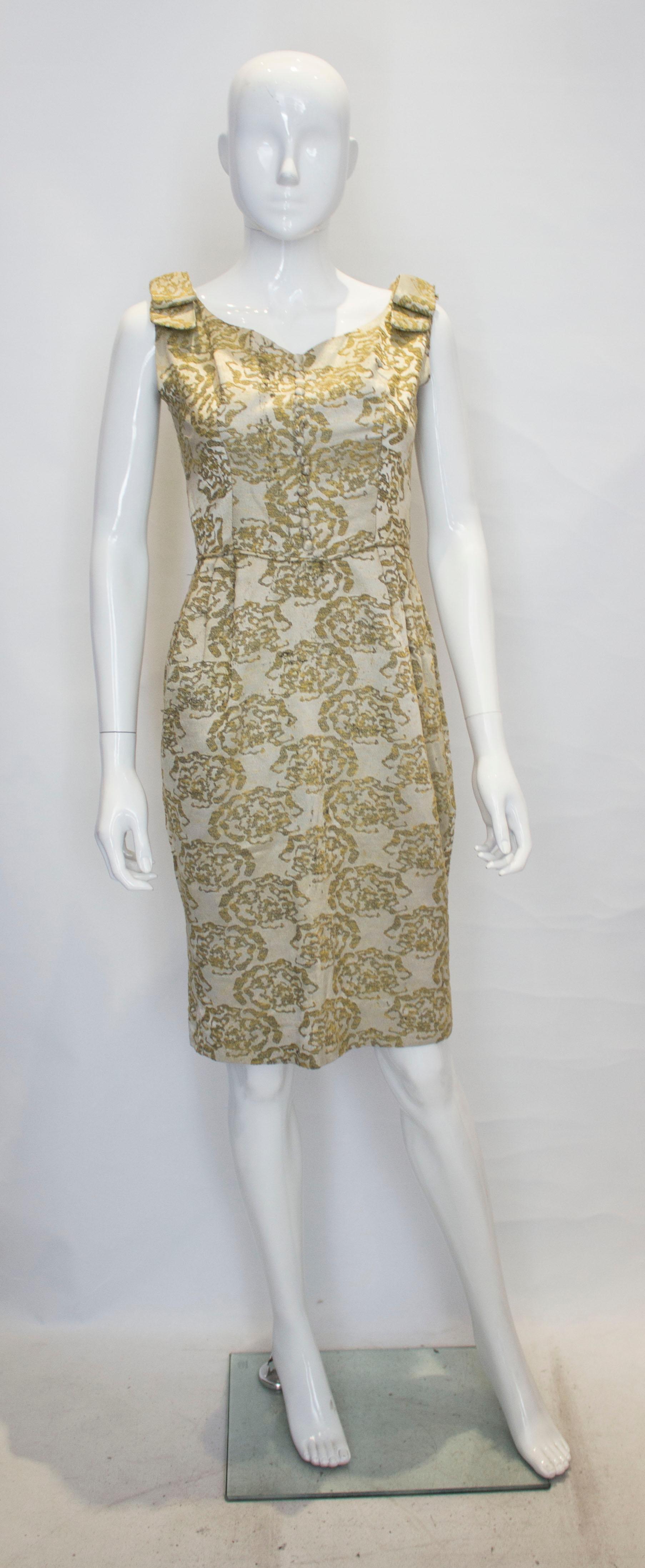 A vintage 1950s - 1960s olive green & gold brocade cinch wiggle cocktail dress 

with matching decrative button up the front 

zip up the back 

measurements taken flat in inches 

bust - 16
waist - 13
length - 38
