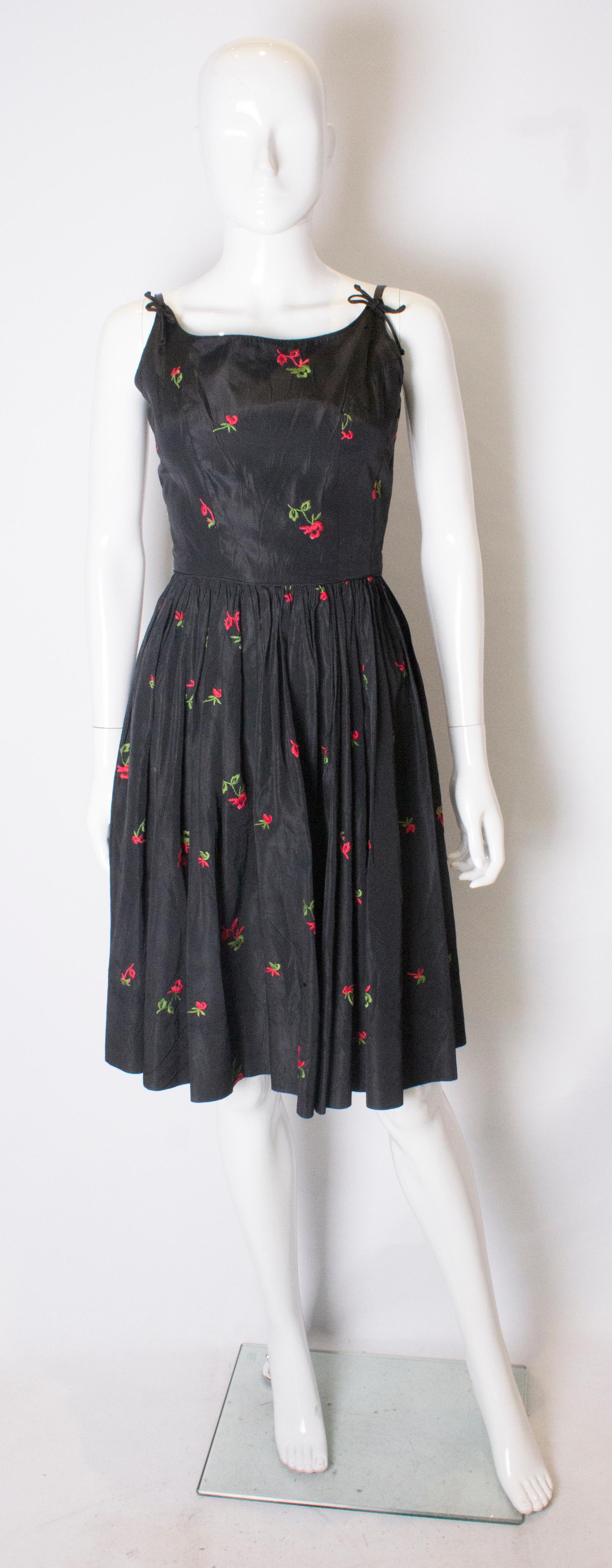 A Vintage 1950s black Rose Embroidered Cinch Swing Dress xs. 

taffeta fabric with red embroidered roses 

measurement taken flat in inches 

bust - 16
waist - 12.5
length - 40
