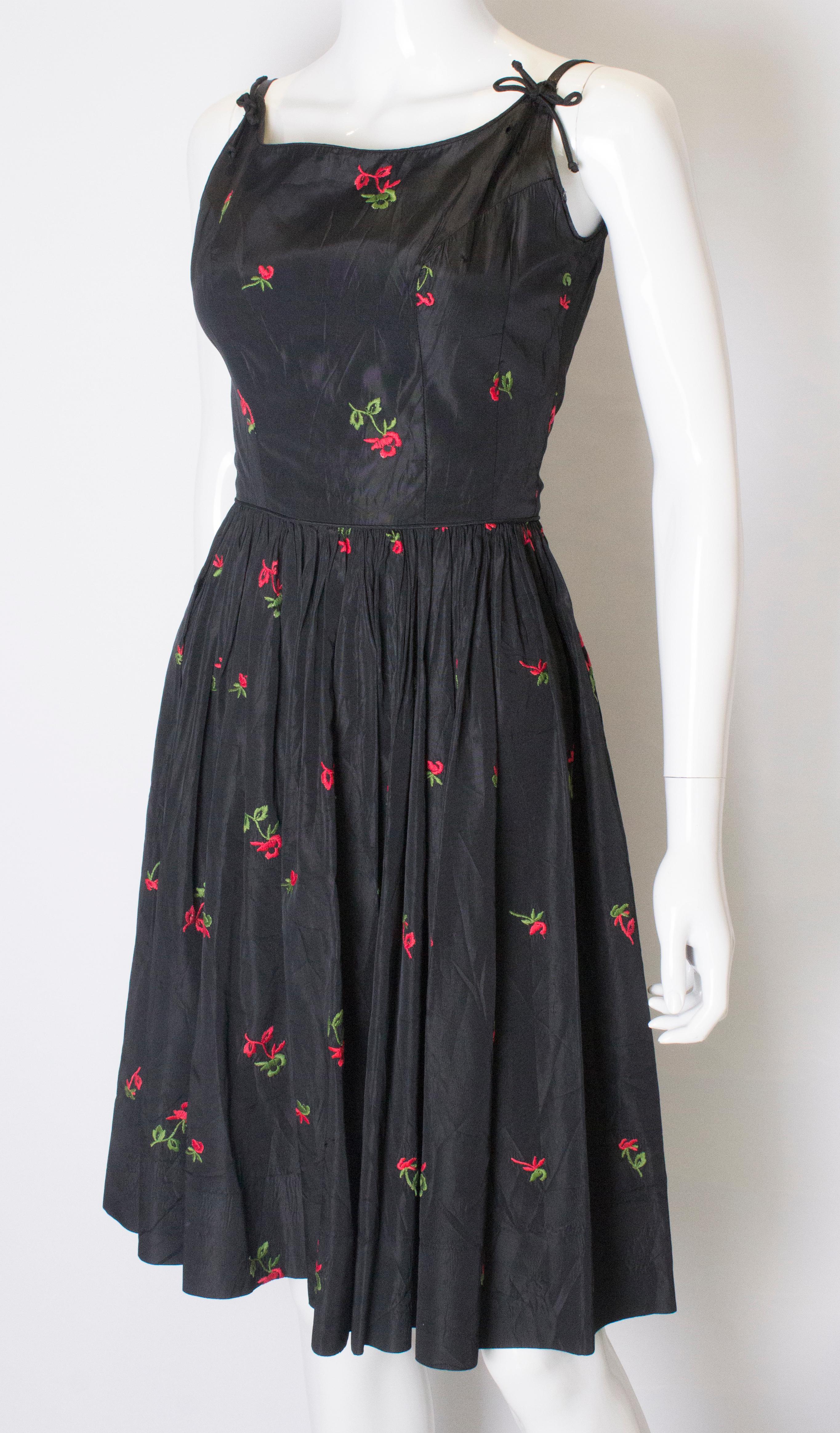 Black A vintage 1950s black cinch swing dress with embroidered flowers 