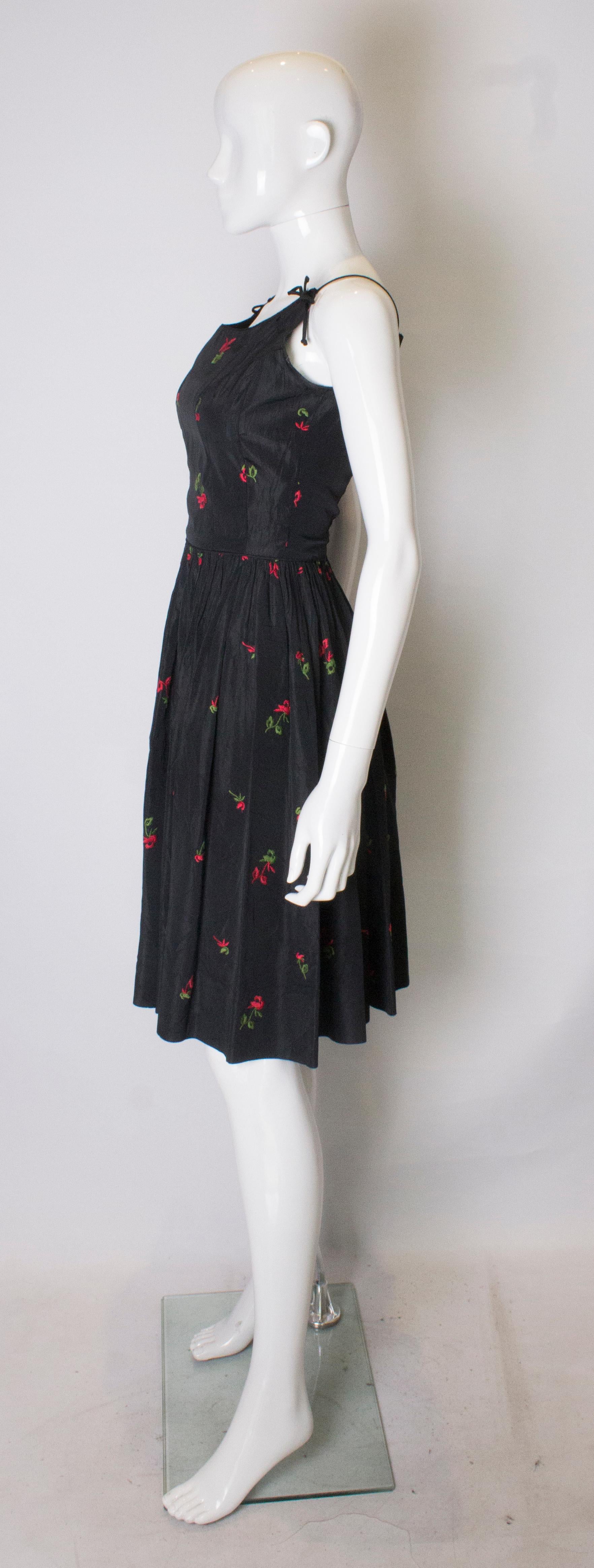 A vintage 1950s black cinch swing dress with embroidered flowers  In Good Condition In London, GB