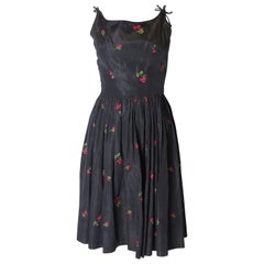 A Vintage 1950s black cinch swing dress with embroidered flowers