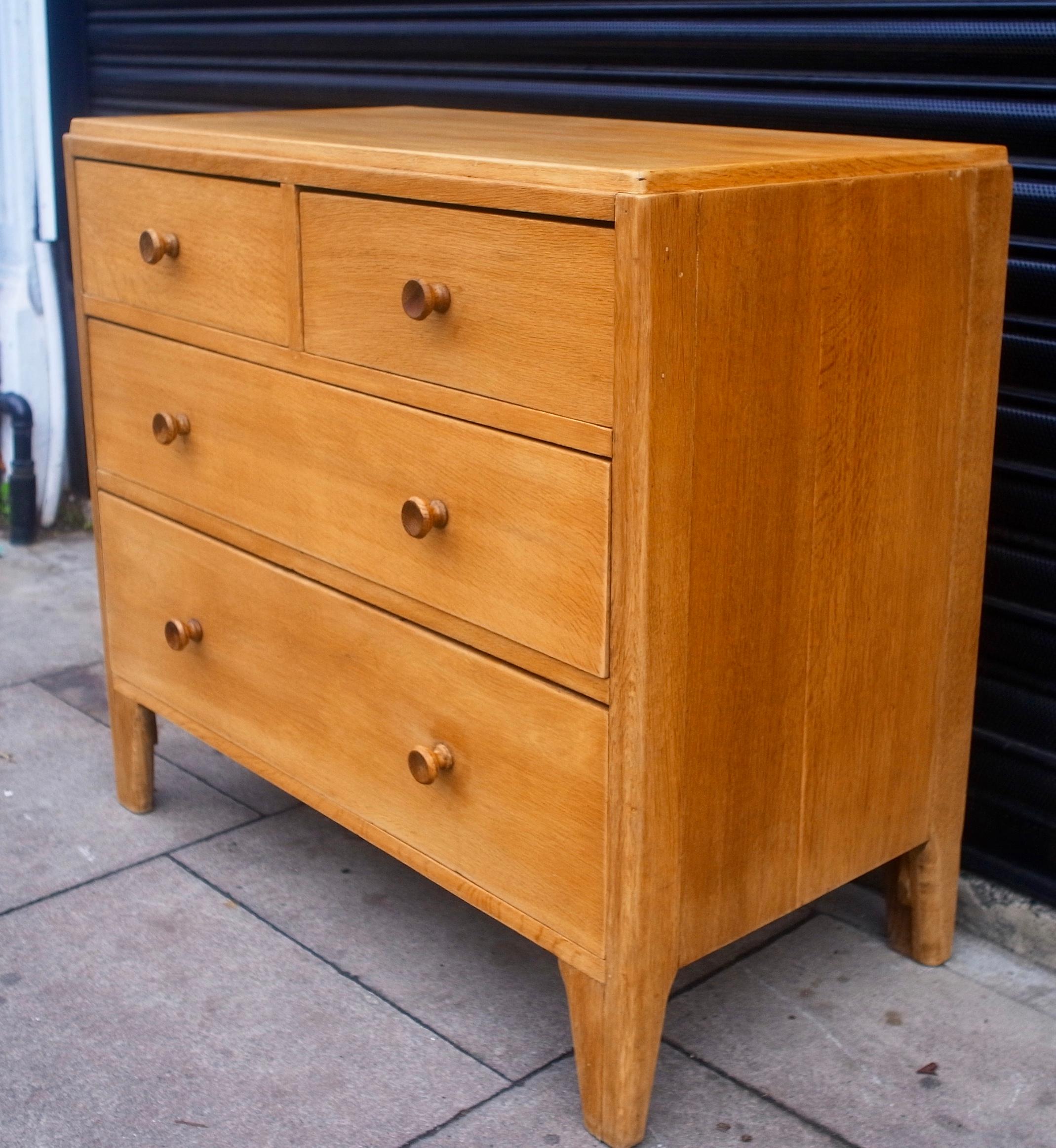 A very stylish and beautifully proportioned vintage 1950s, military issue Oak veneered, chest of four drawers, with two smaller drawers set over two larger. This piece was manufactured by British company 'W.M. Lawrence & Co Ltd', and is in very good