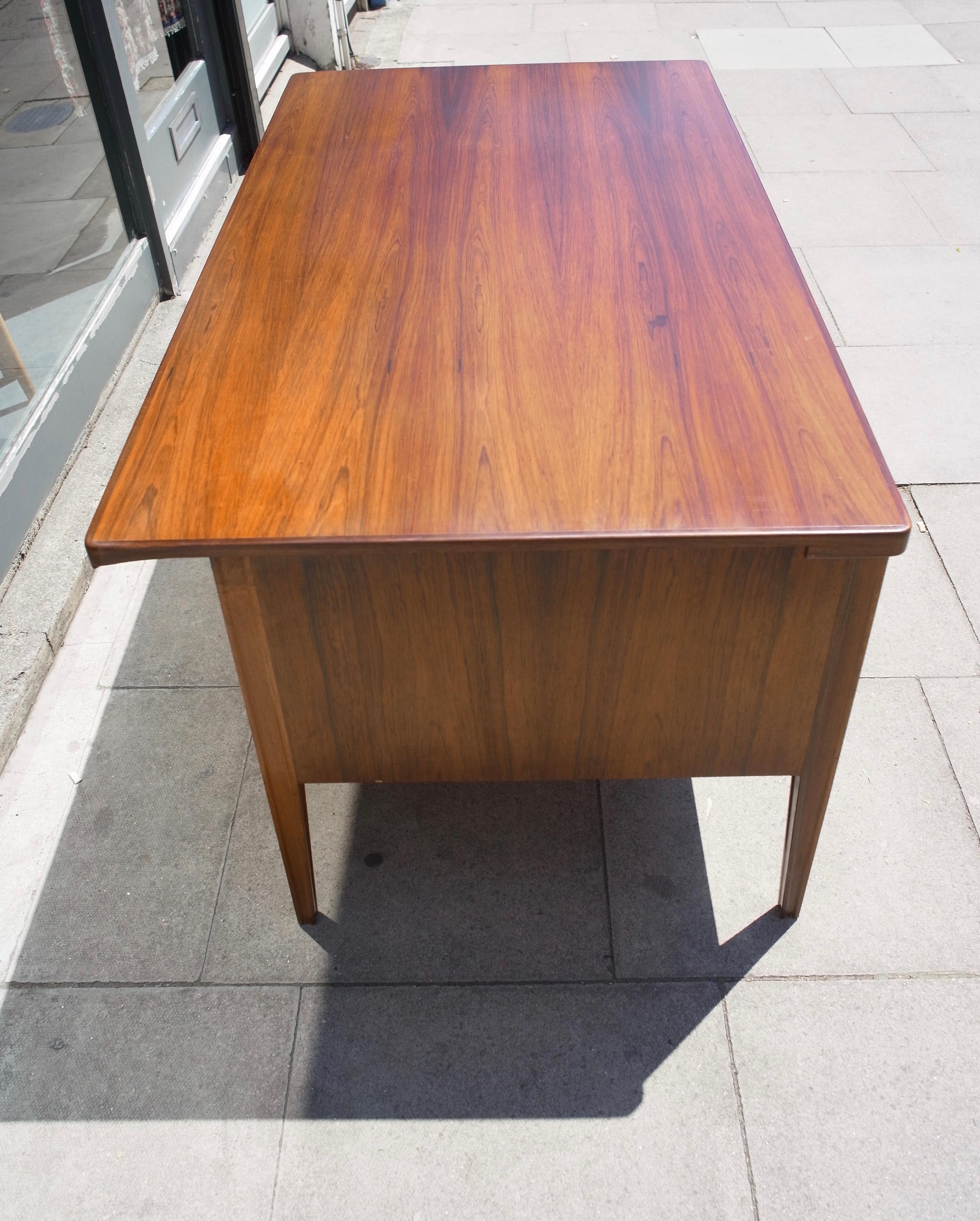 A very fine and stylish 1960s vintage three drawers on one side and a filing cabinet drawer on the other, Danish desk in Rosewood with brass handles. This desk is in good vintage condition, the wood, having been, waxed and cleaned. Although, the