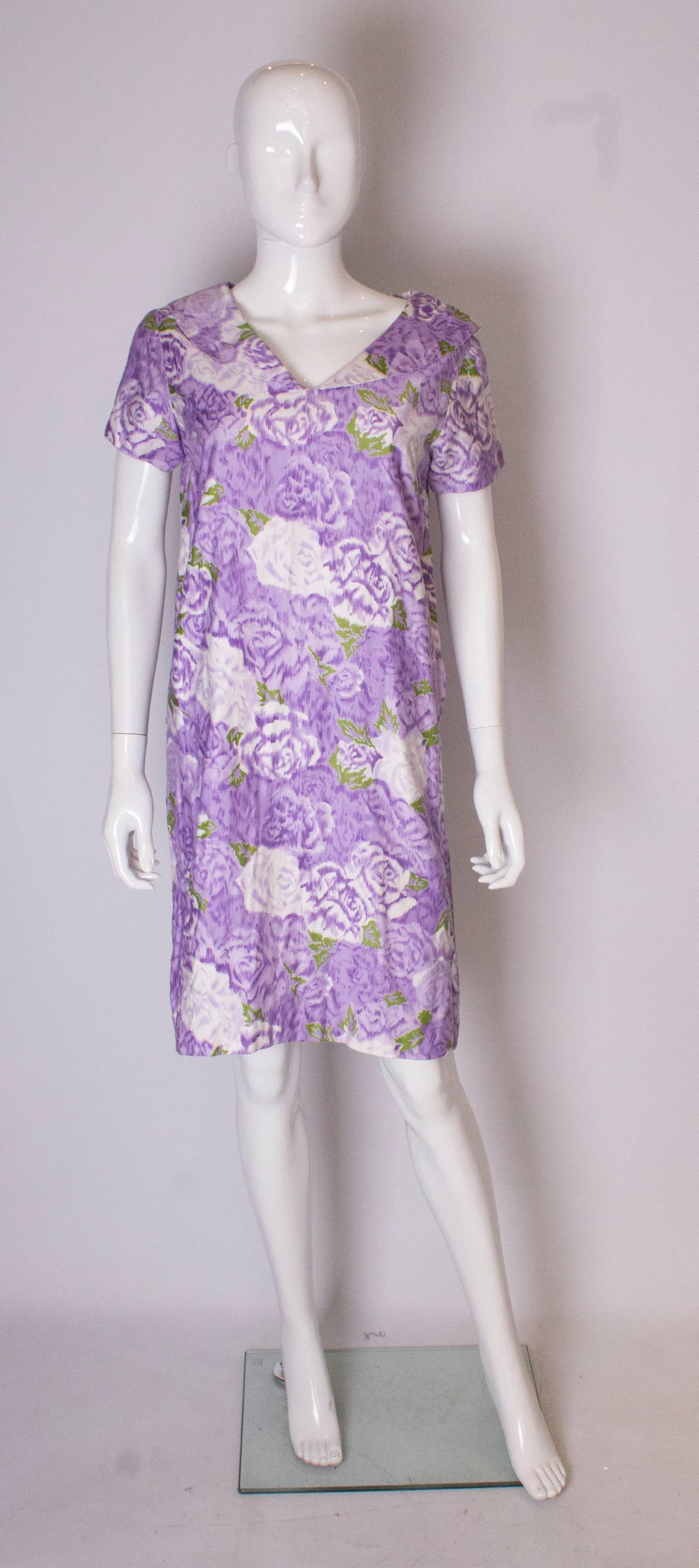 A pretty vintage cotton smock dress , in a lilac and green print. The dress has a shawl collar, cap sleeves and a side zip.  It is fully lined.