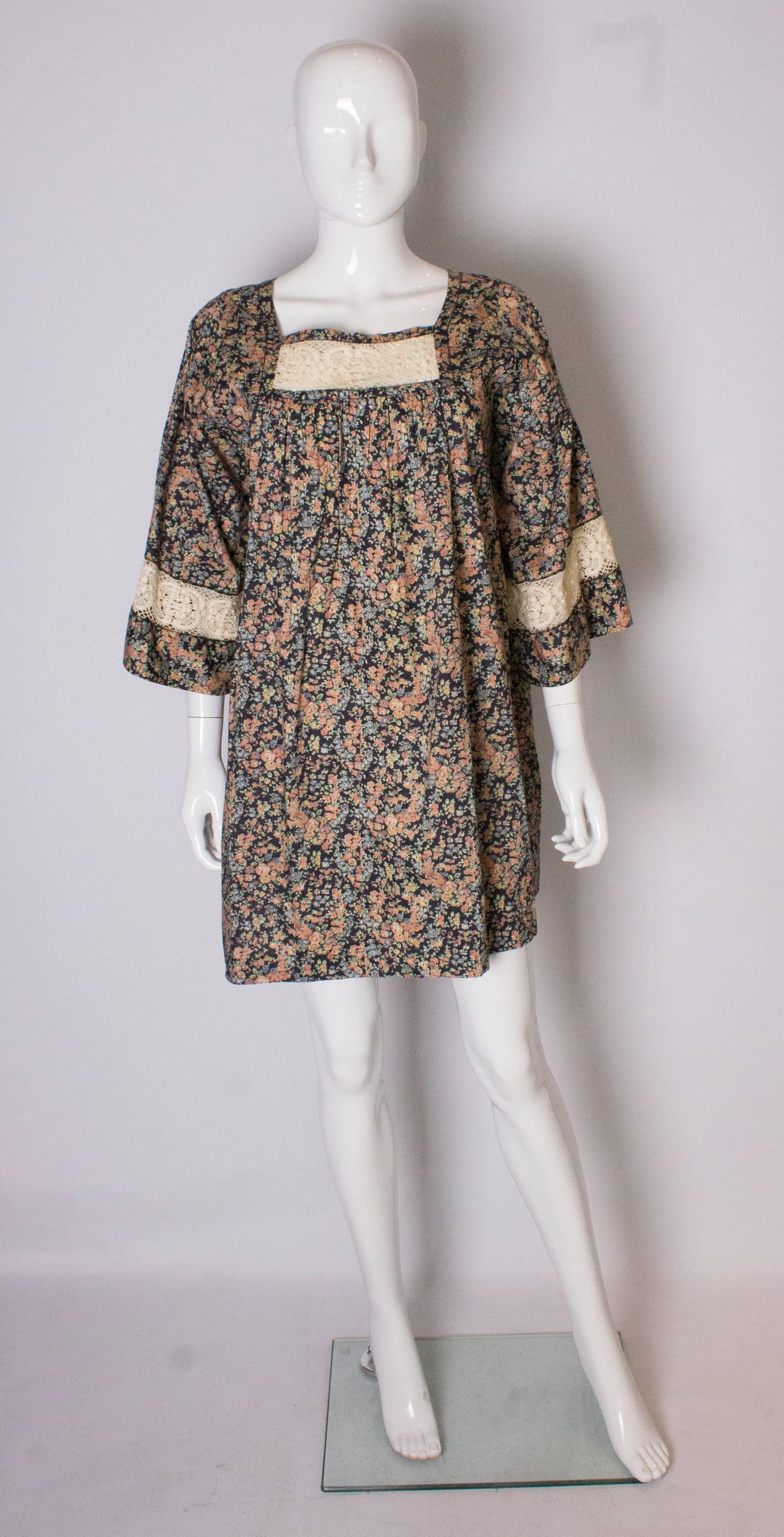 A pretty vintage top for Spring/Summer. In a Liberty floral print, by Sara Ferni, with a black background, the top has a lace trim over the bust and at the end of the sleeves. The top is marked size M , and will fit a bust up to 40'' ,length 33''