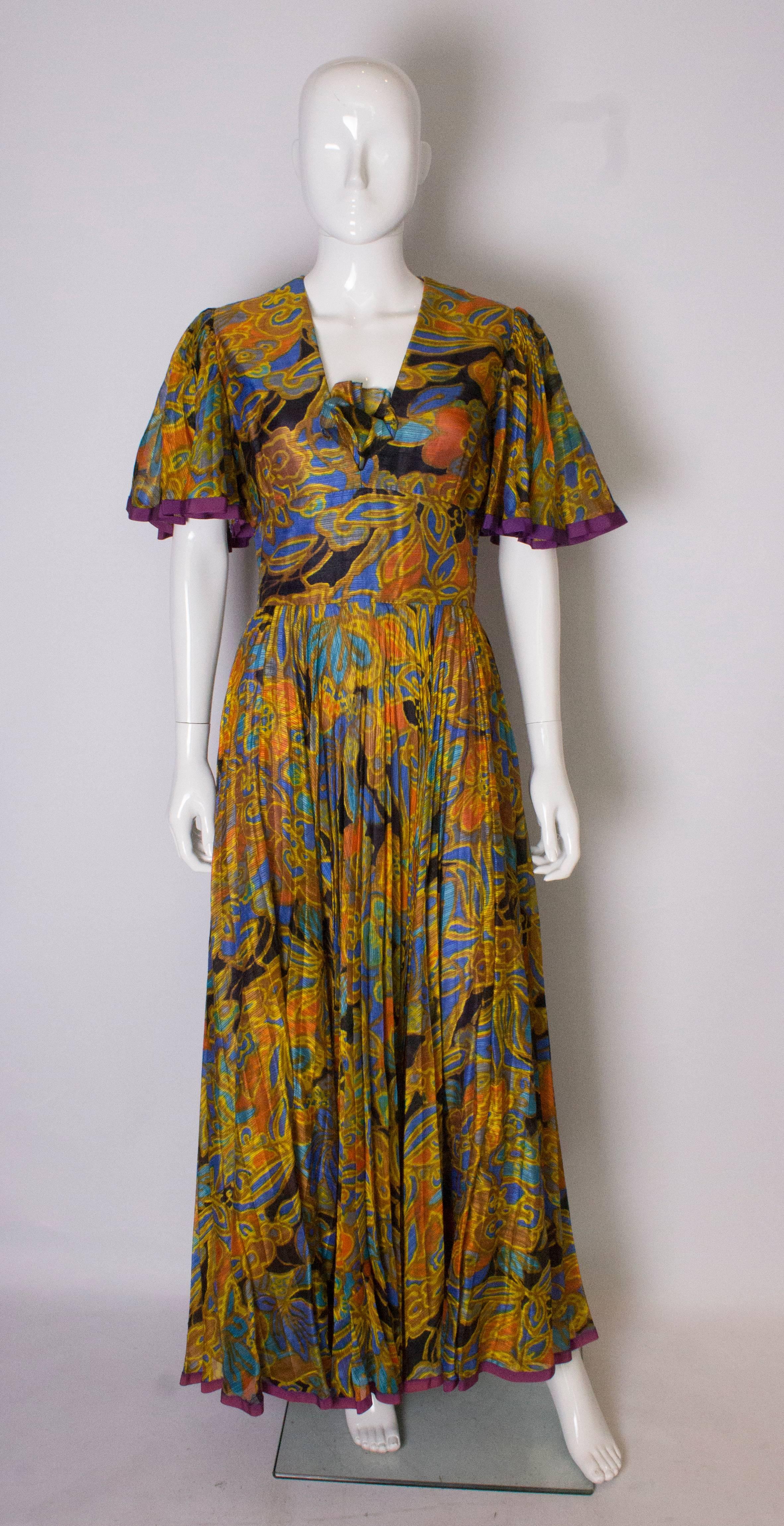 A pretty vintage gown by Ross Bergo for Harrods. The dress is multicoloured with a purple trim . It has a detachable modesty panel , ie removing it will make the gown have a more defined v neckline. It has a central back zip , and angel sleaves.