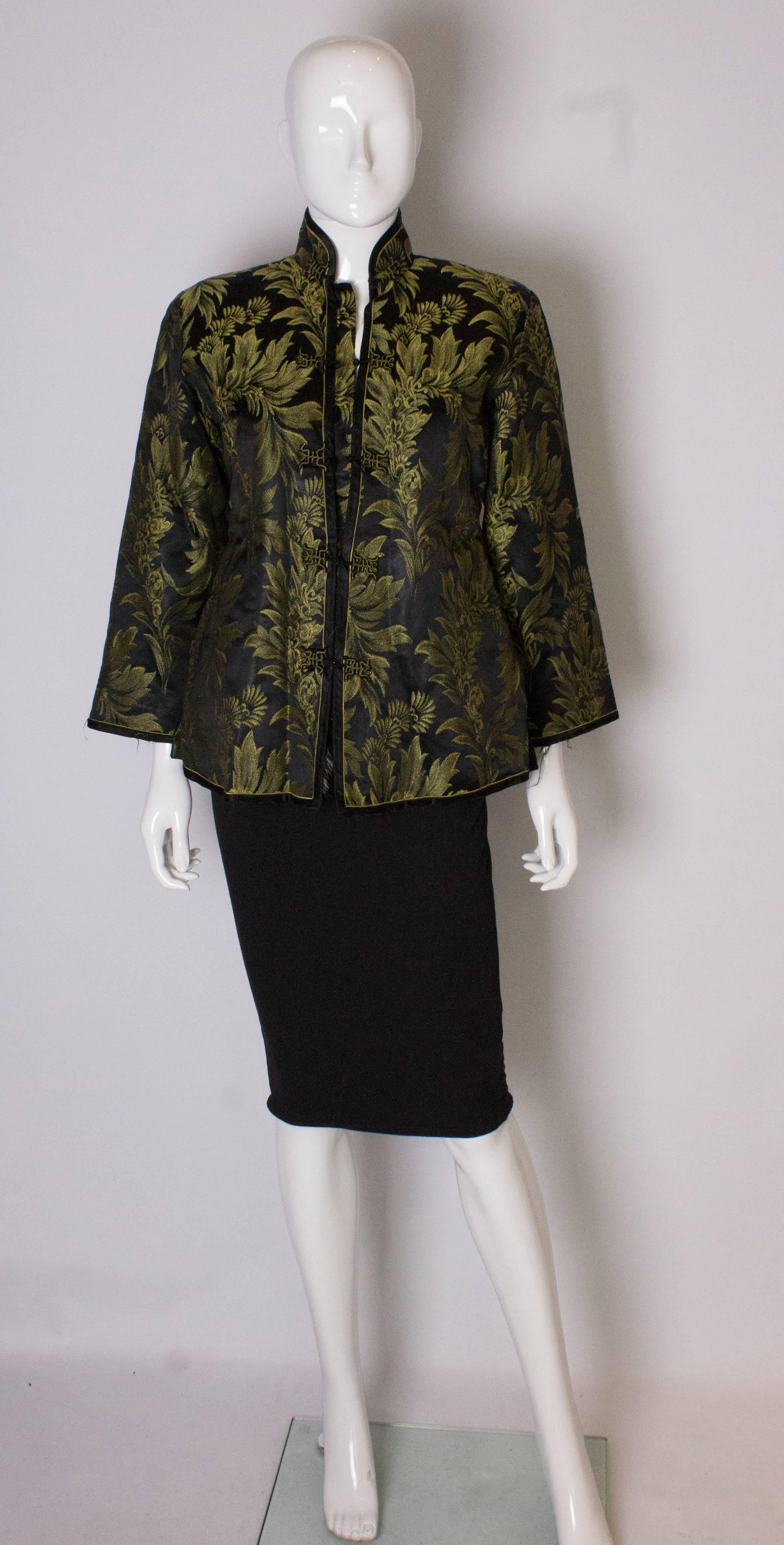 Une veste chinoise vintage chic doublée de fourrure. La veste est en soie noire avec un motif floral jaune/vert, et est doublée de fourrure. Il se ferme à l'aide de boutons-pression et présente des fentes de 6'' sur le côté.