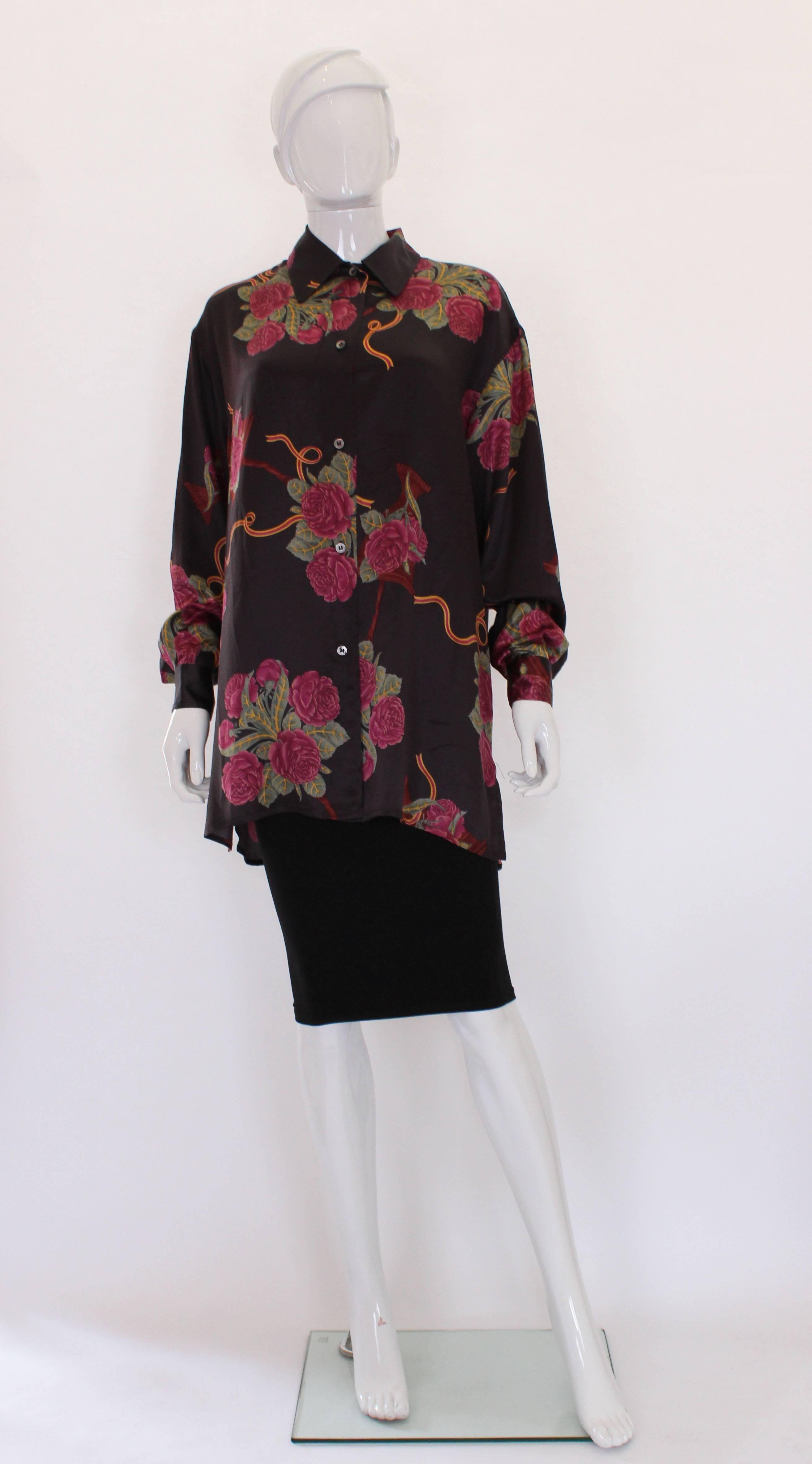 A great silk overshirt by Salvatore Ferragamo.This shirt is in a beautiful silk, with a brown background and pink floral print.The shirt has a one button cuff, and 5 button opening at the front.All the buttons are stamped Ferragamo, and the shirt