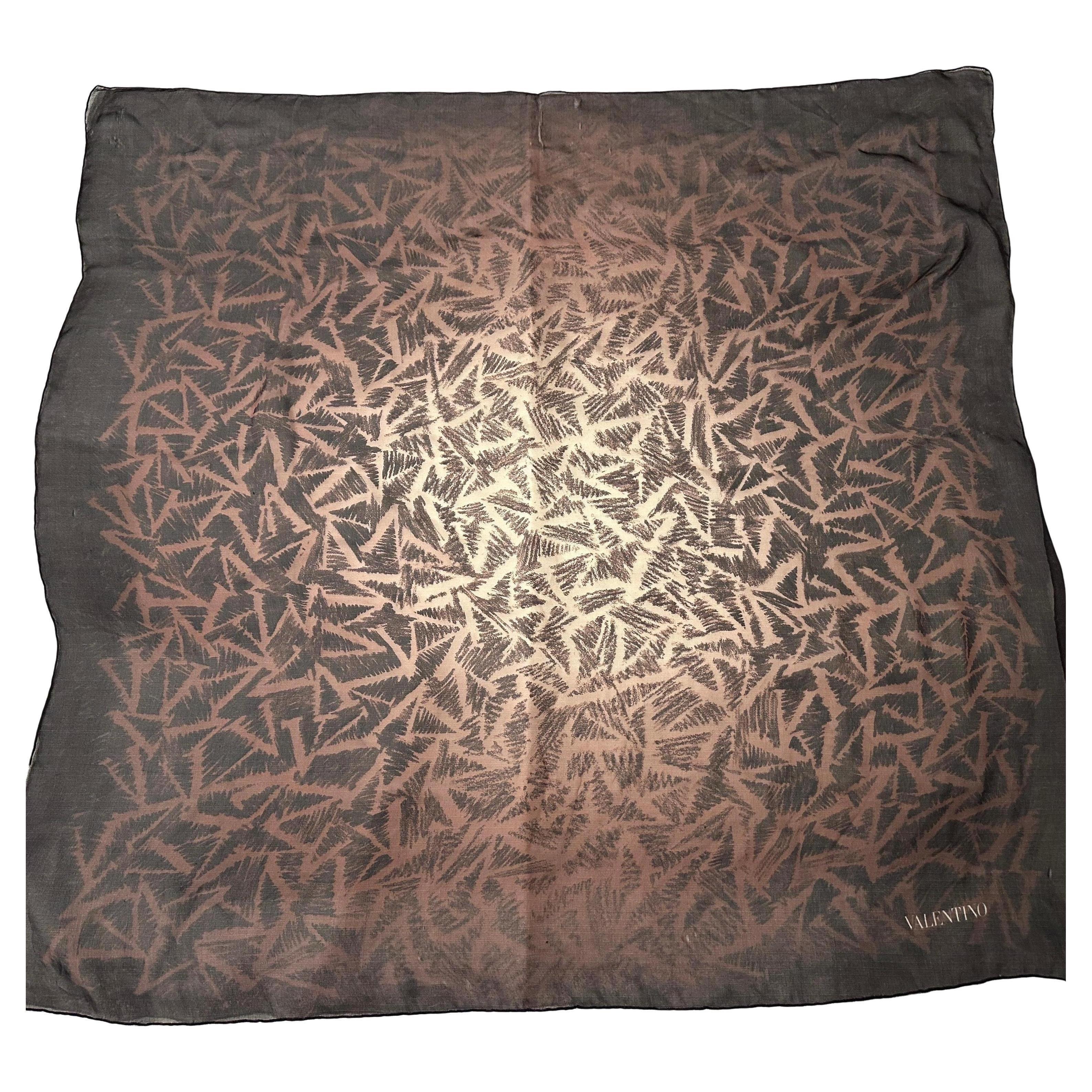 Si tratta di un foulard di seta vintage degli anni '80 di Valentino, che mostra l'eleganza e il design artistico tipici del marchio. La sciarpa presenta un effetto sfumato che passa da un centro morbido e caldo a un bordo esterno più scuro, quasi