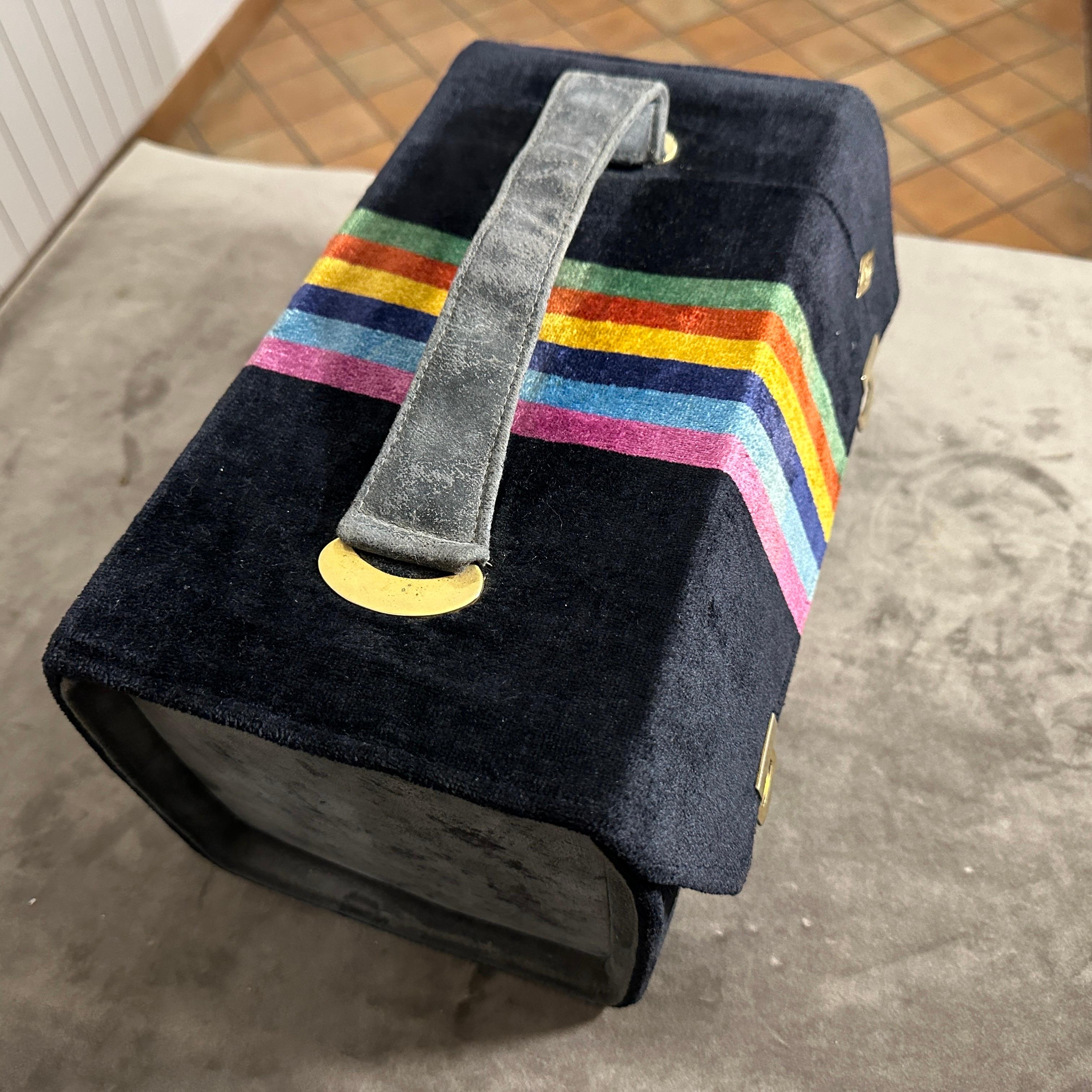 This is a vintage 1980s velvet beauty case by Leda, an Italian brand known for its luxurious and stylish designs. The case features a striking blue and gray velvet exterior with a multicolored vertical stripe pattern in shades of pink, blue, yellow,