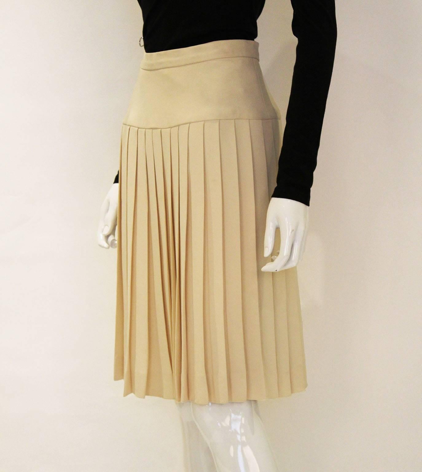 A wonderful silk skirt by Chanel .This skirt is in a lovely pale cream colour. The skirt fabric is a very heavy silk ( the pleats hang beautifully ) and the lining is silk with the Chanel logo worked into the fabric. The pleats start at hip level,