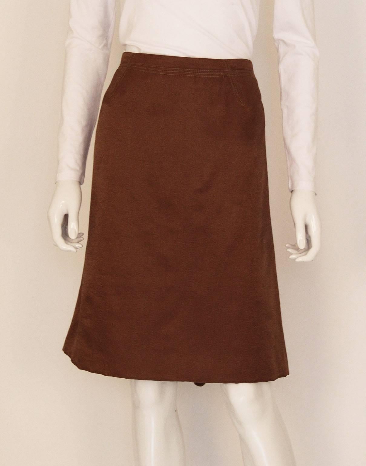 A wonderful bronze coloured skirt by Nina Ricci, Paris. The skirt is made of a luxurious wool mix, and is fully lined. There is a double row of stitching on the waist band , and the back has an interesting zig zag detail and gathering.
It is marked