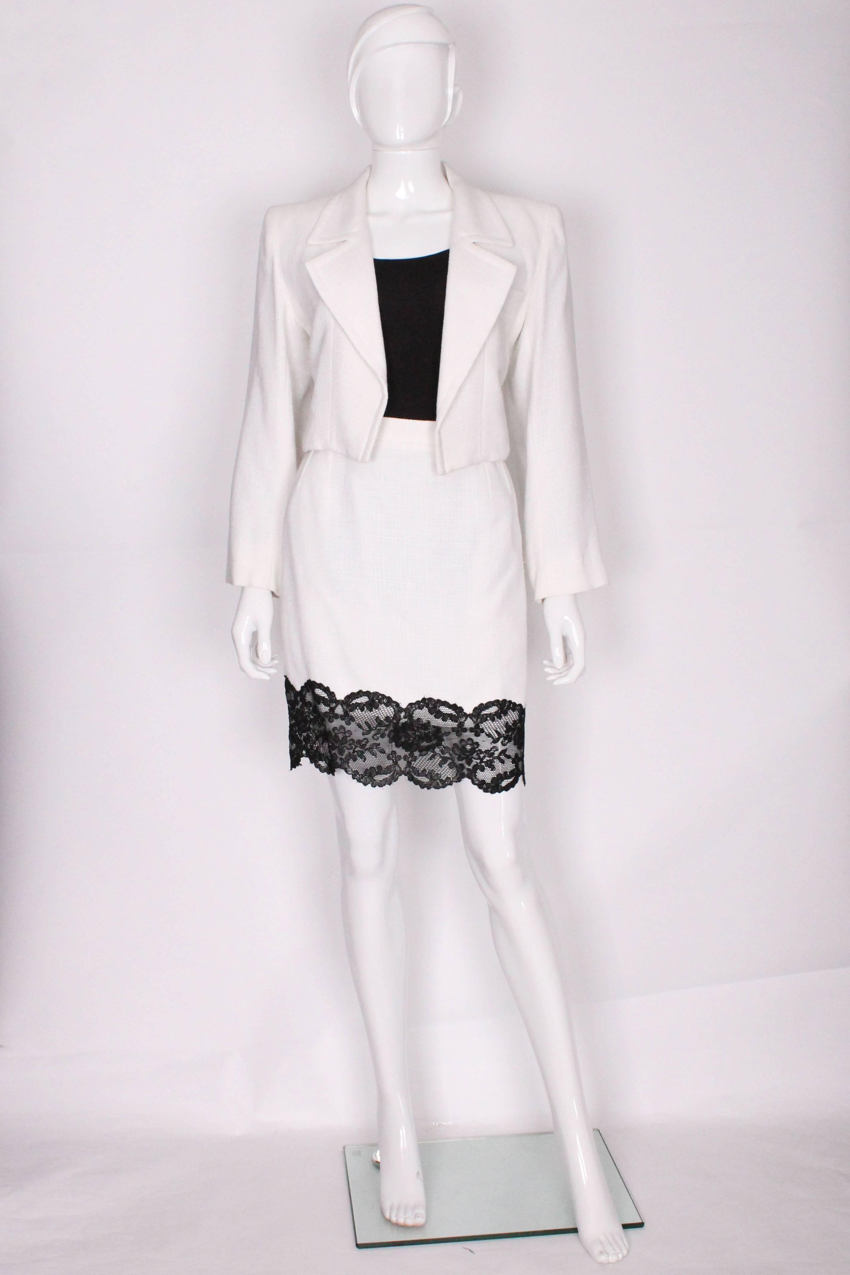 A super suit by French designer Yves Saint Laurent. The cropped jacket is tuxedo style with a pocket on the left breast. The short skirt is edged with black lace and has a side zip and pocket on the left hand side.
The jacket is a size 40 , bust